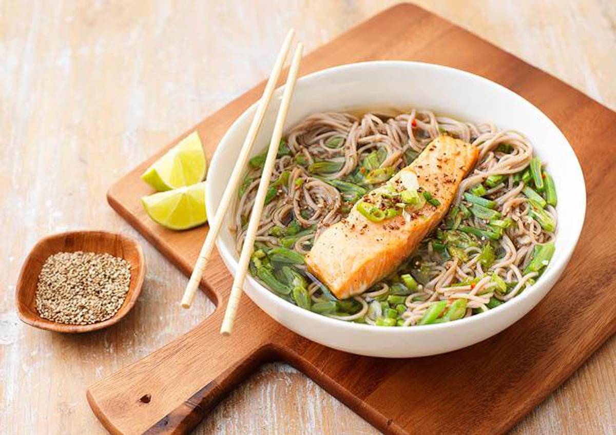 Heldere soep met noedels, groene groenten en zalmfilet
