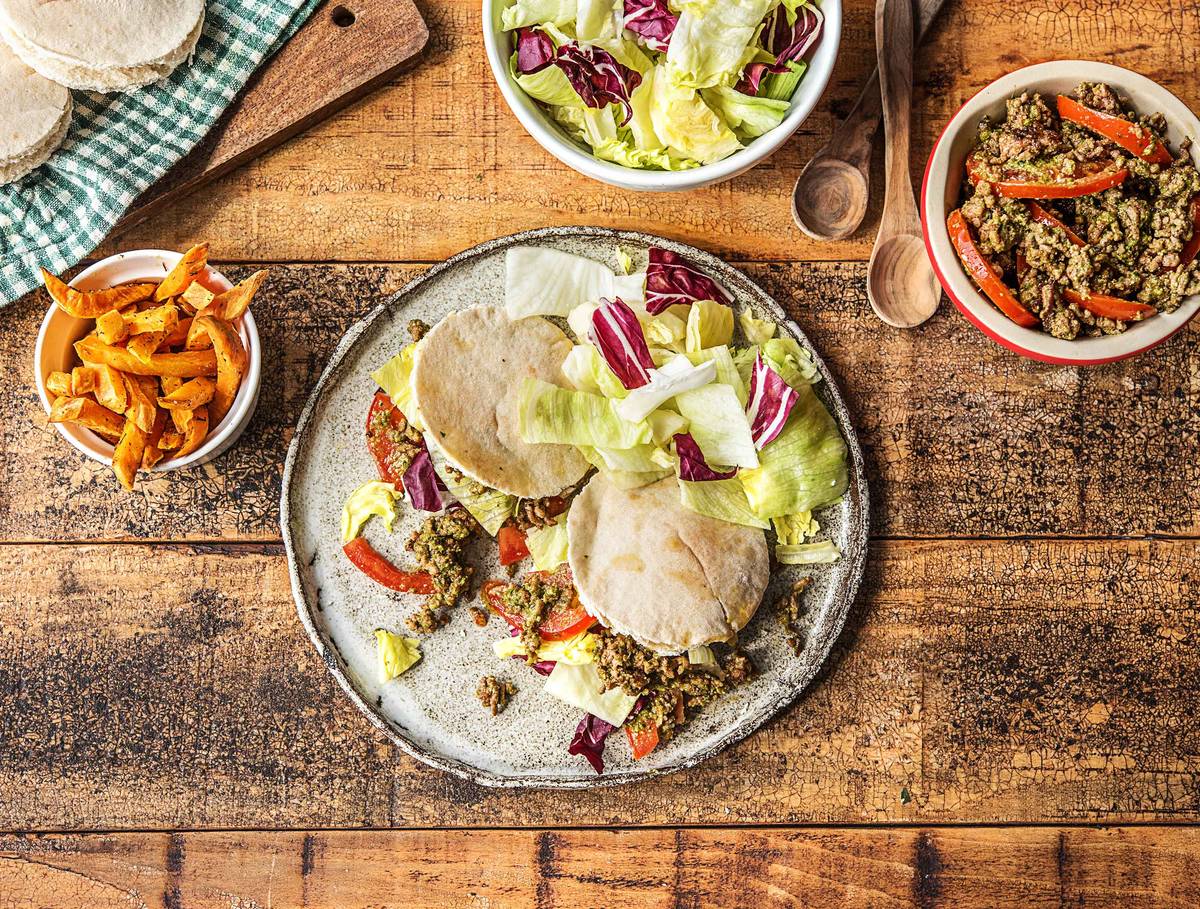 Italiaanse pitabroodjes met gehakt, tomaat-pestosalade, bataat en knapperige ijsbergsla