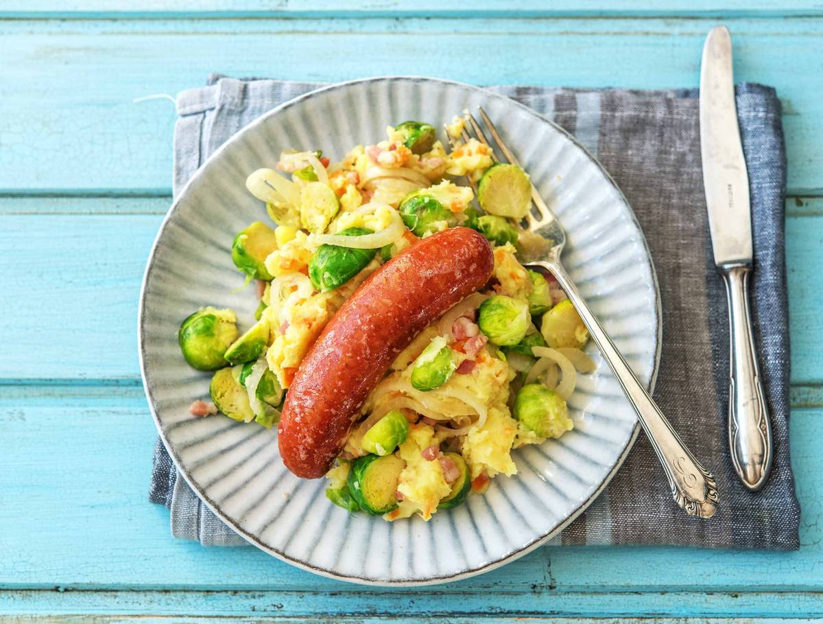 Hutspot hollandais aux lardons servi avec une saucisse fumée