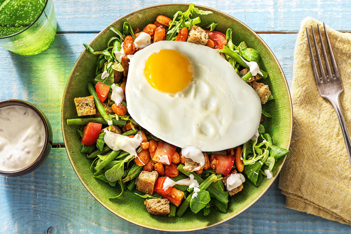 Salade de haricots, croûtons et œuf au plat