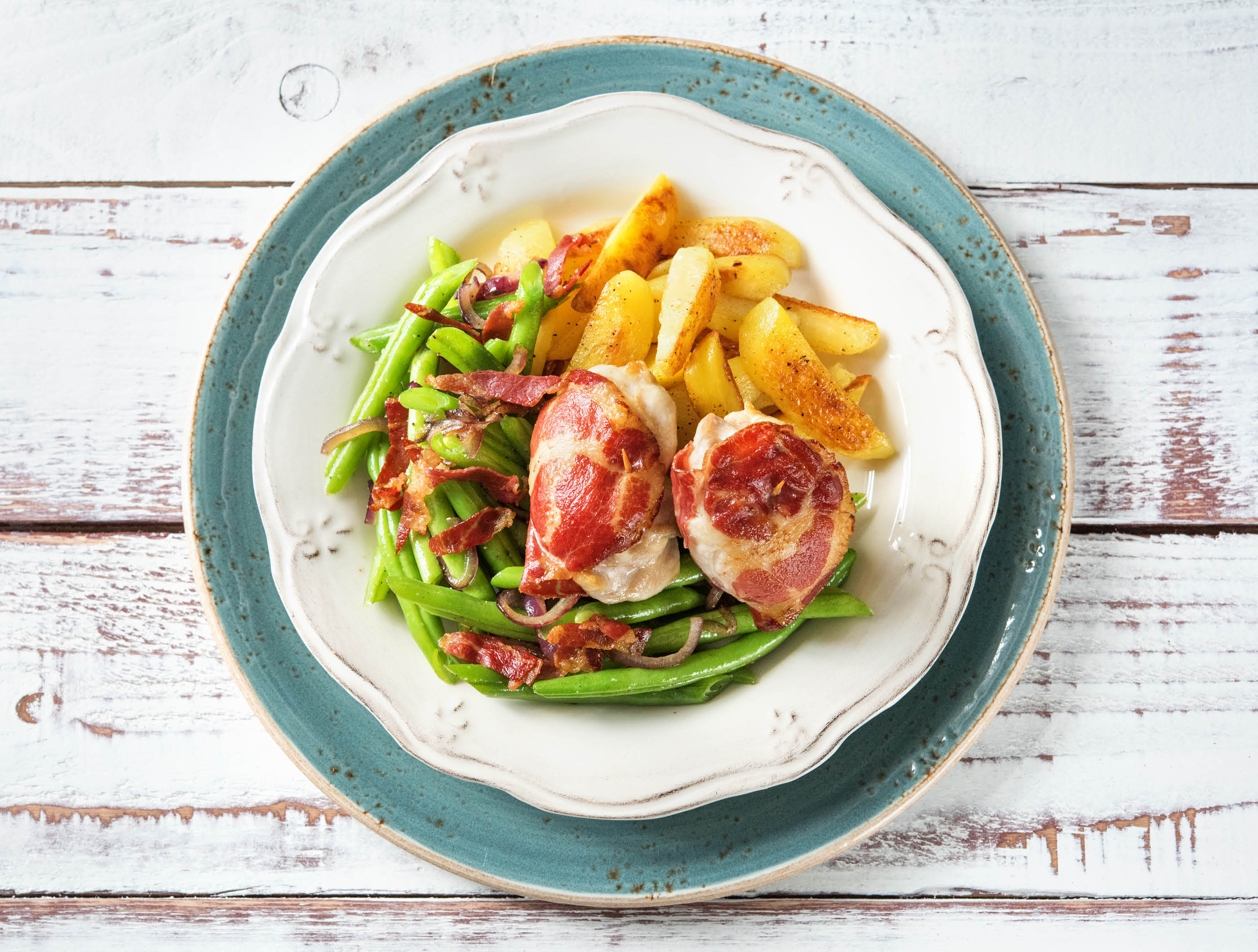 Kippendij met coppa di parma, knoflookboontjes en gebakken aardappelen