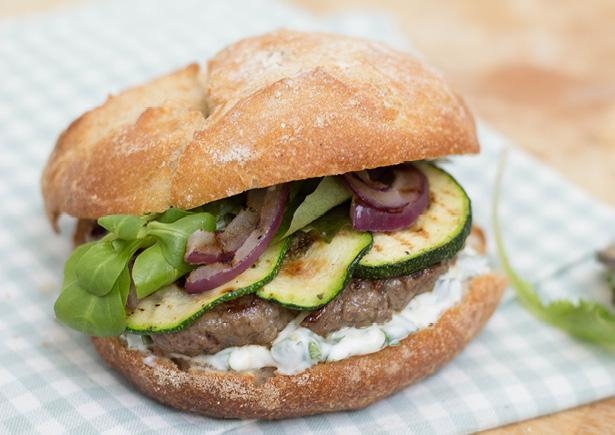 Broodje hamburger met gegrilde groenten, yoghurtsaus en frisse salade