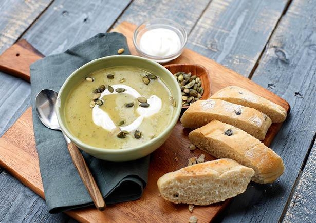 Romige aardappel-courgettesoep met pompoenpitten en olijfbrood