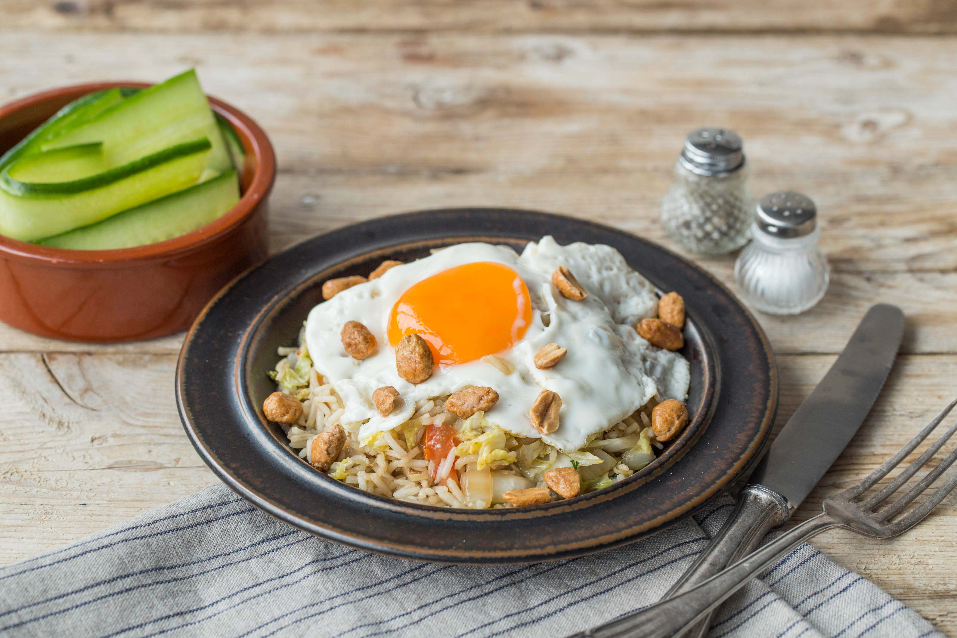 Rijst met honingpinda’s, spiegelei en zoetzure komkommer