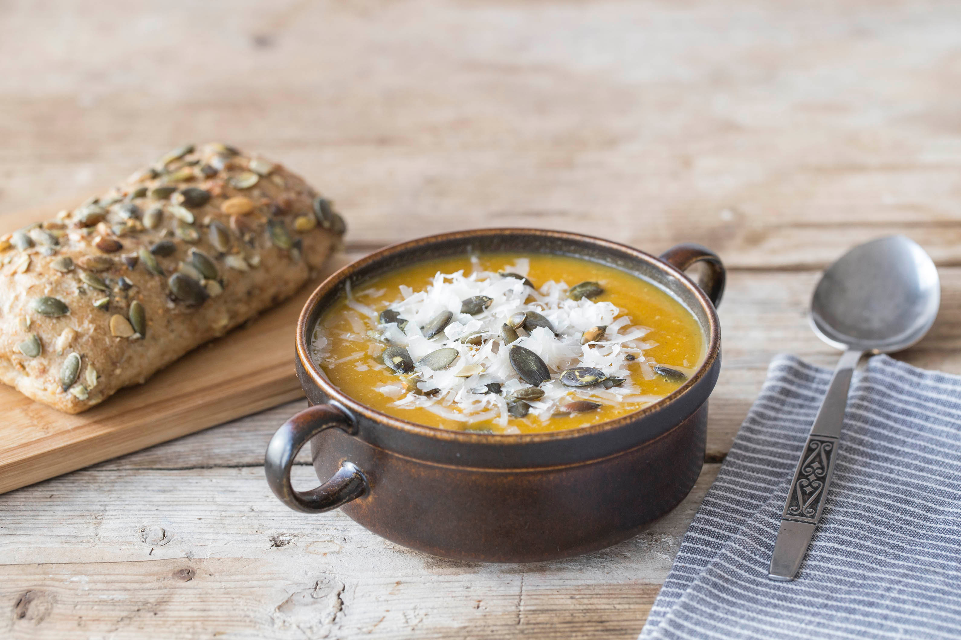 Kruidige pompoensoep met grana padano en pompoenpitbrood