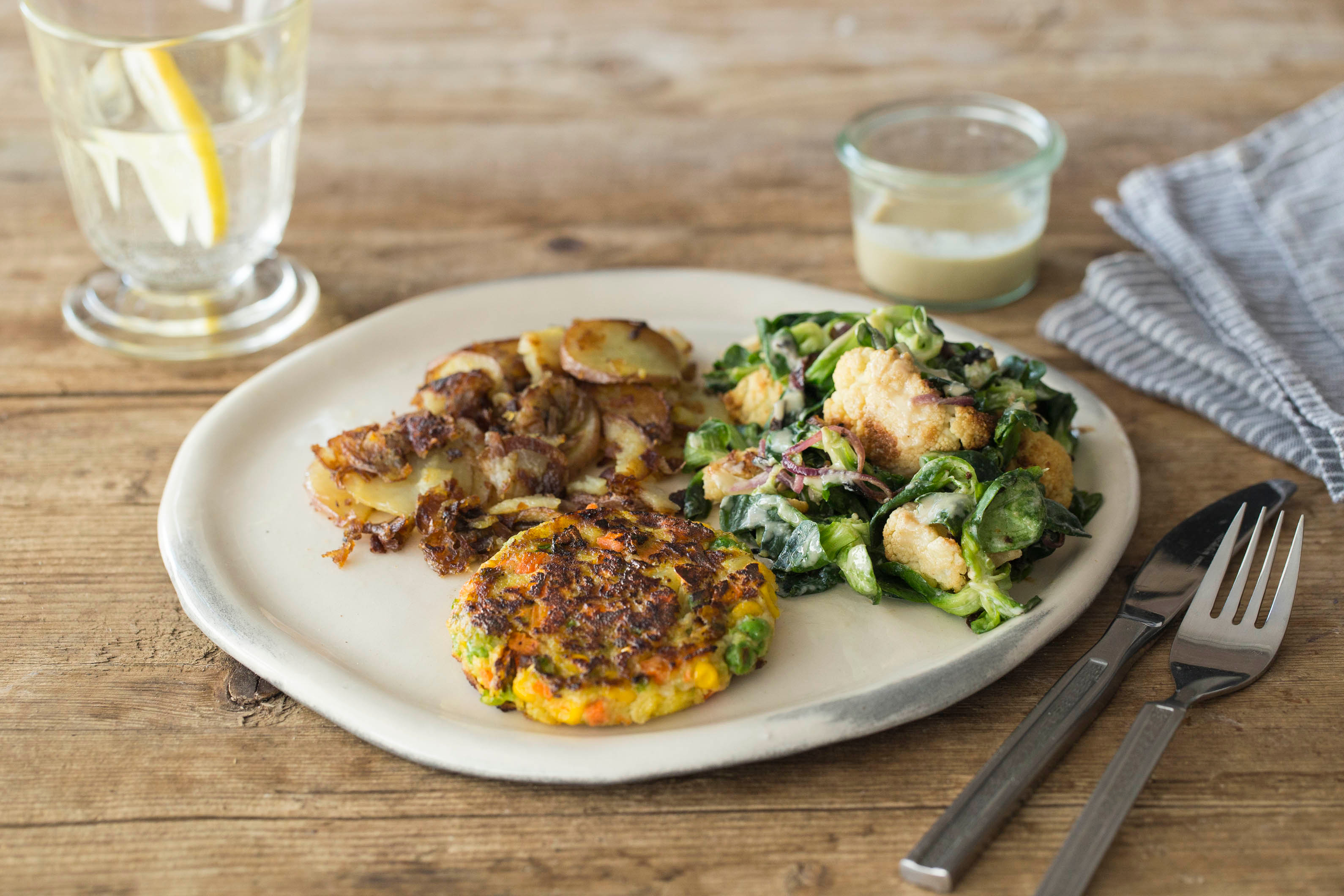 Vegetarische burger met aardappelen en salade van geroosterde bloemkool