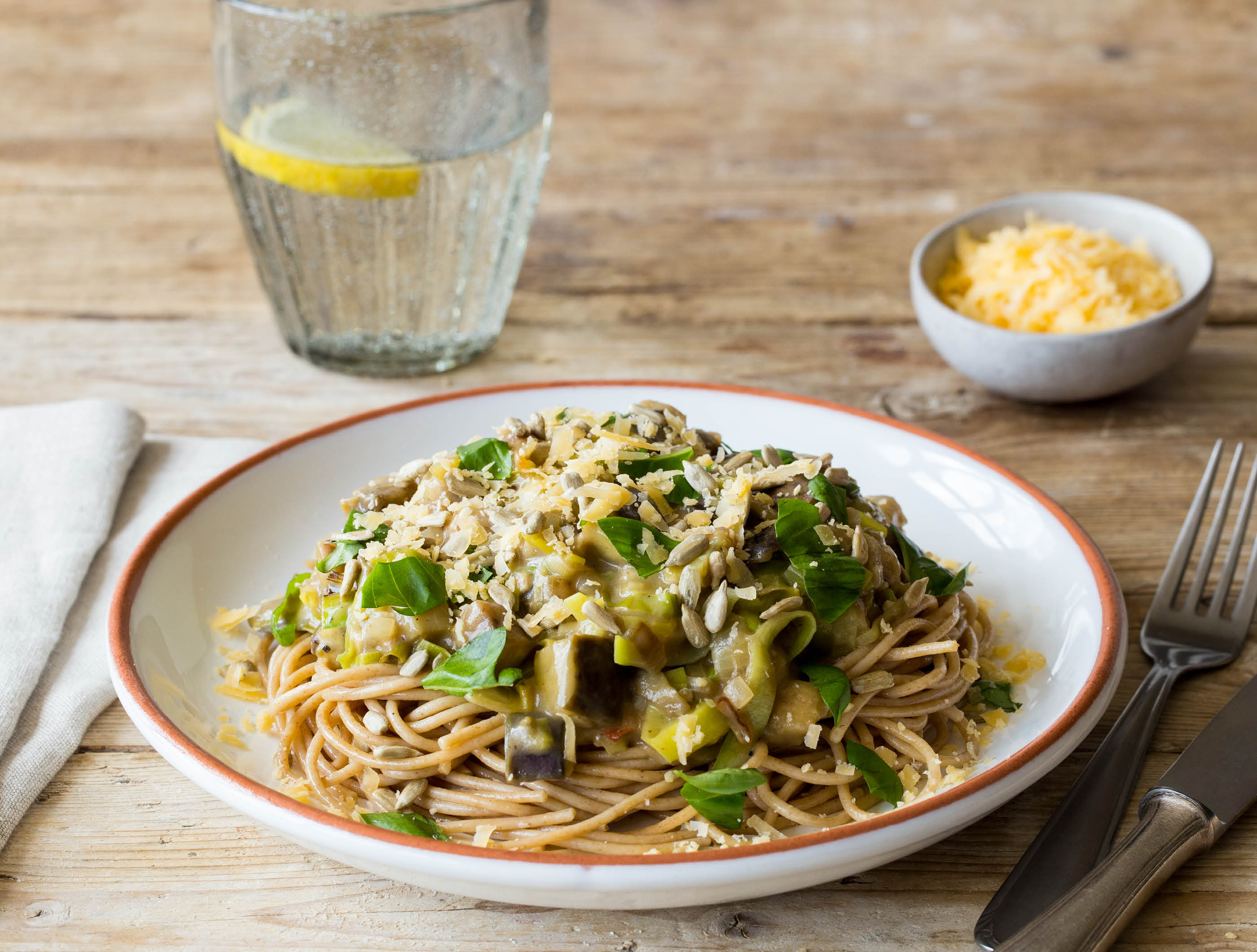 Romige spaghetti met geroosterde zonnebloempitten, oude kaas en verse basilicum