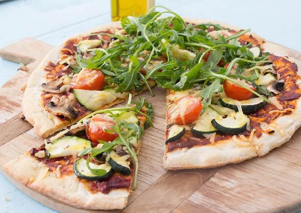 Pizza met verse groenten, rozemarijn en rucola