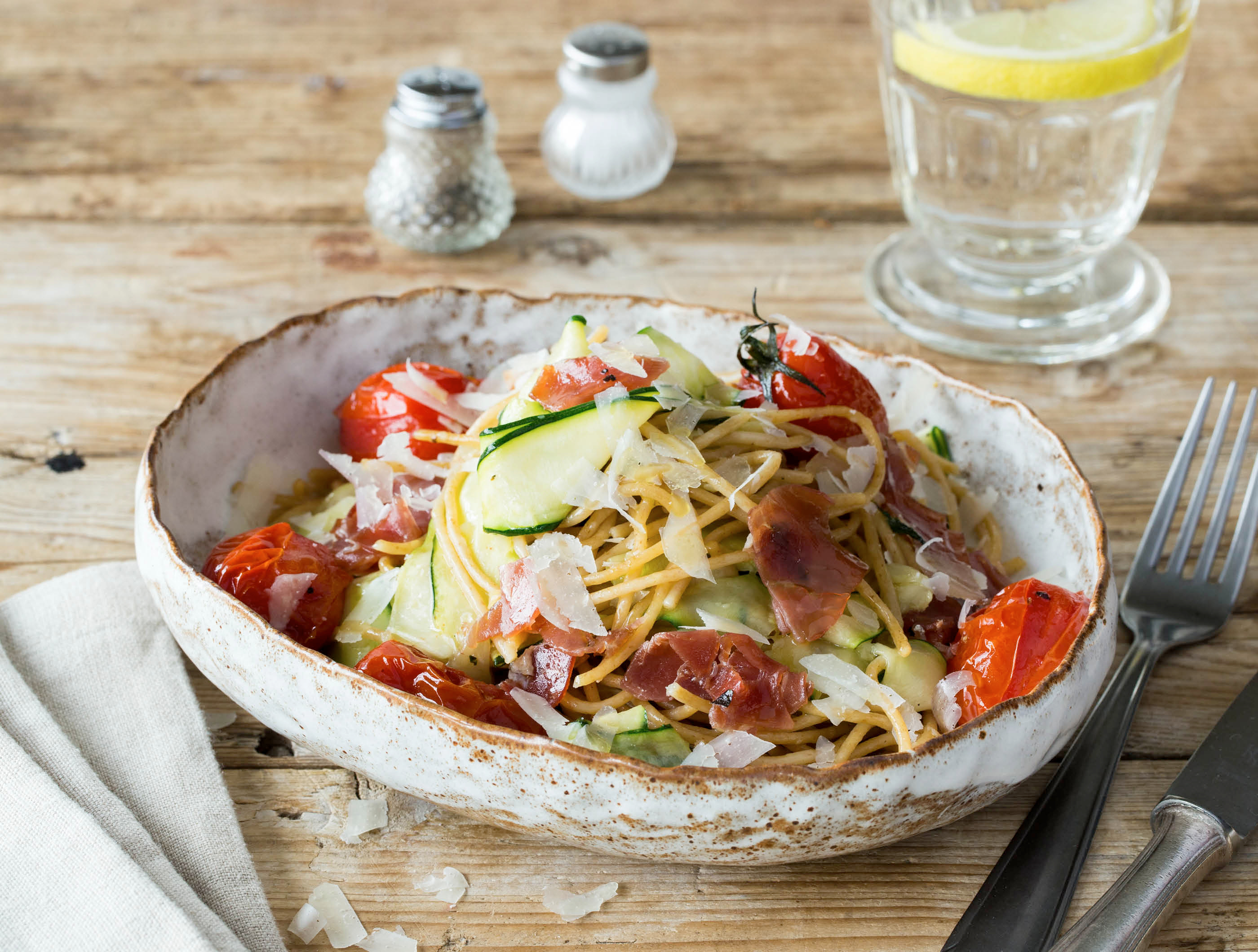 Spaghetti met serranoham, courgettelinten en romatrostomaten uit de oven
