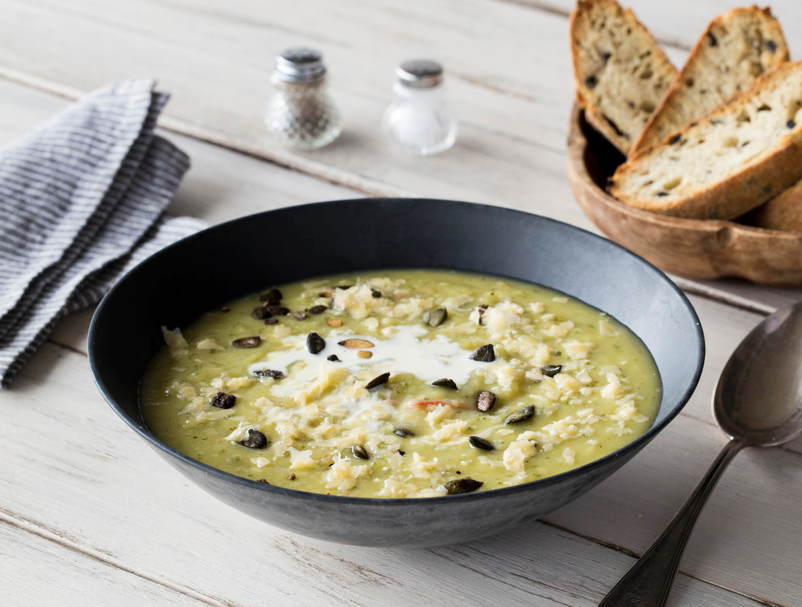 Romige aardappel-courgettesoep met pompoenpitten en olijfbrood