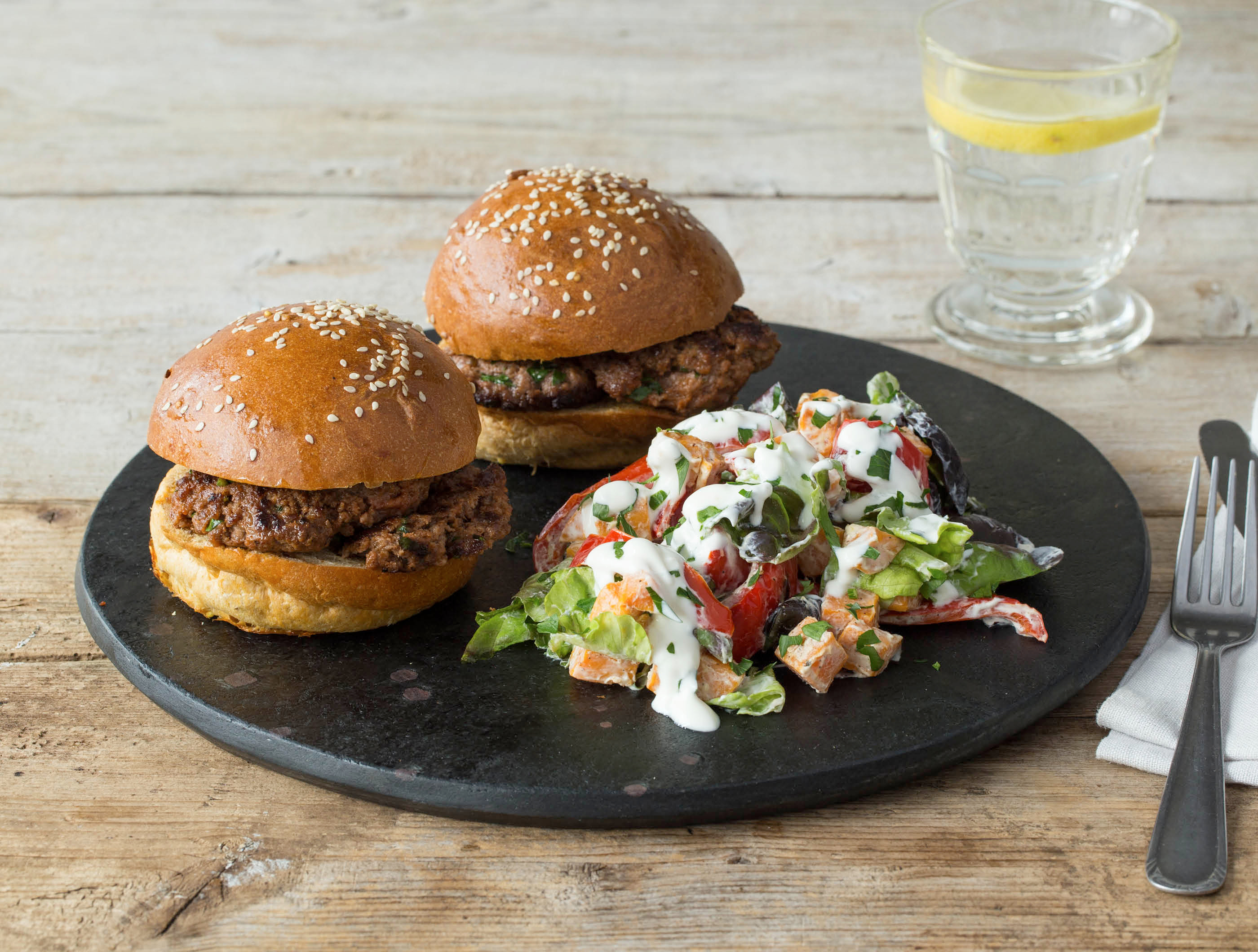 Runderburgers met volkoren broodjes en zoete aardappelsalade