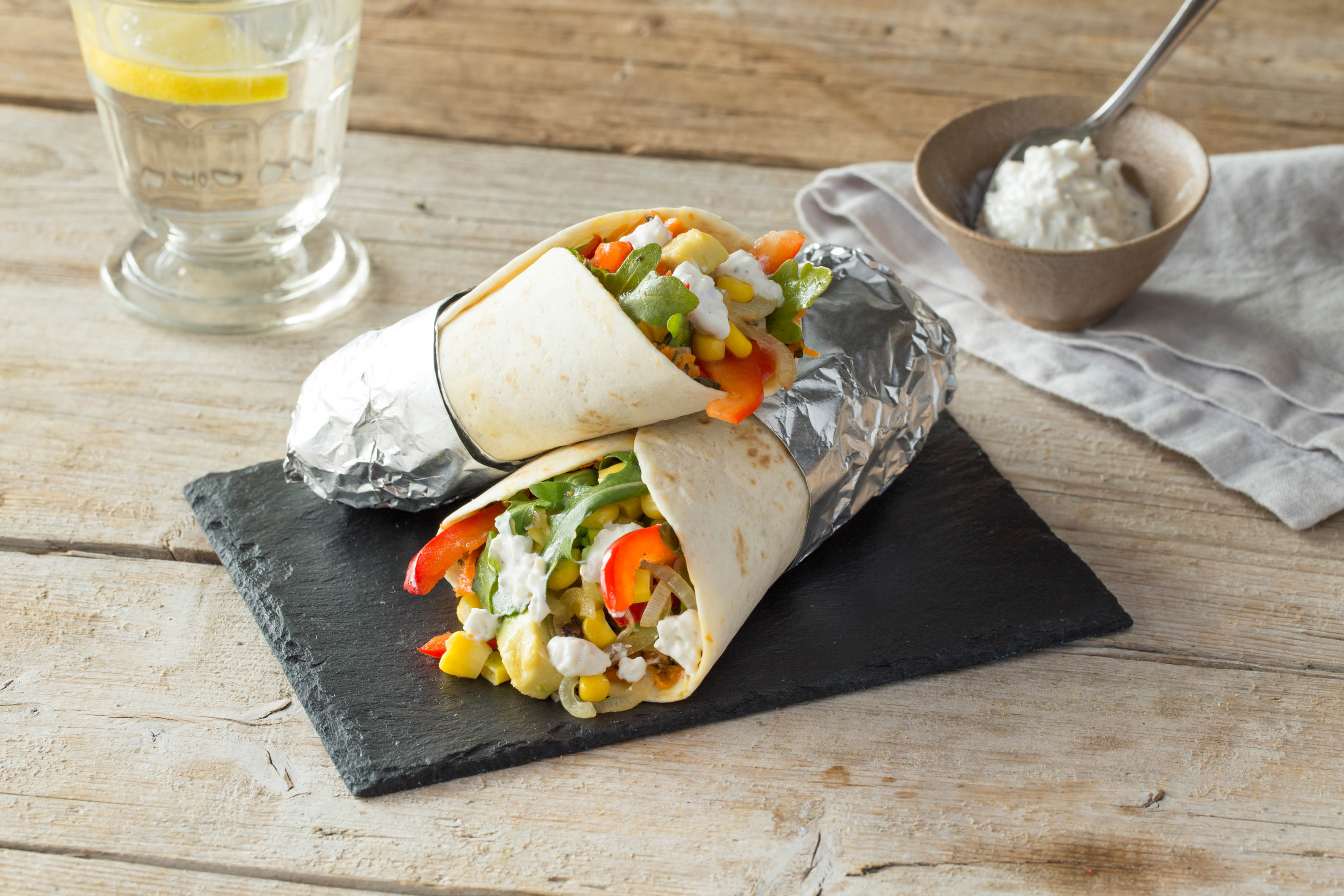 Bunt gefüllte Wraps mit Avocado, Rucola und Zuckermais,