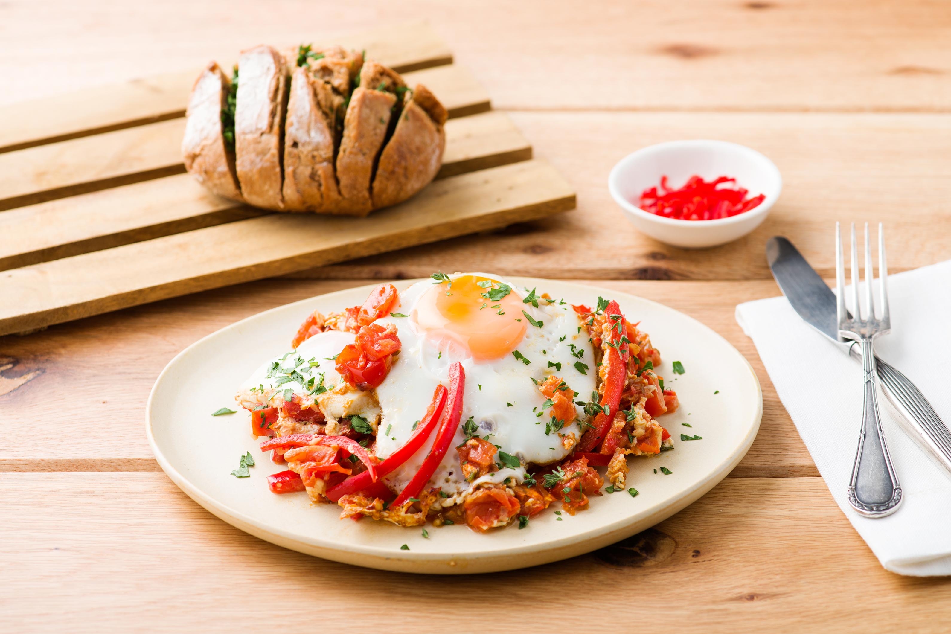 Traditionele shakshuka met ei en bruin rozenbroodje