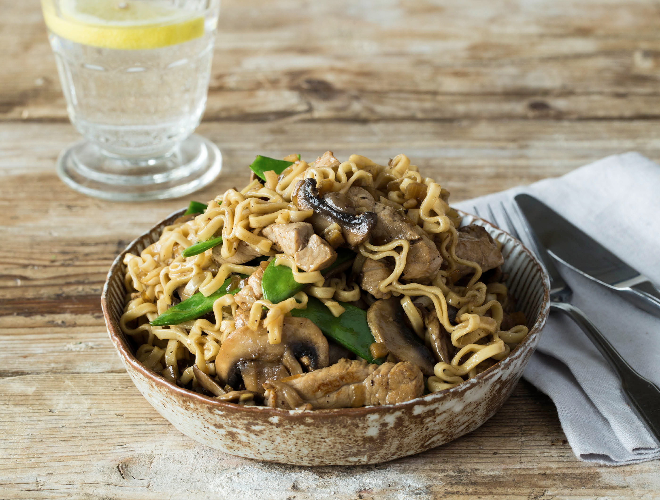 Oosterse wok met varkenshaasreepjes, champignons en peultjes