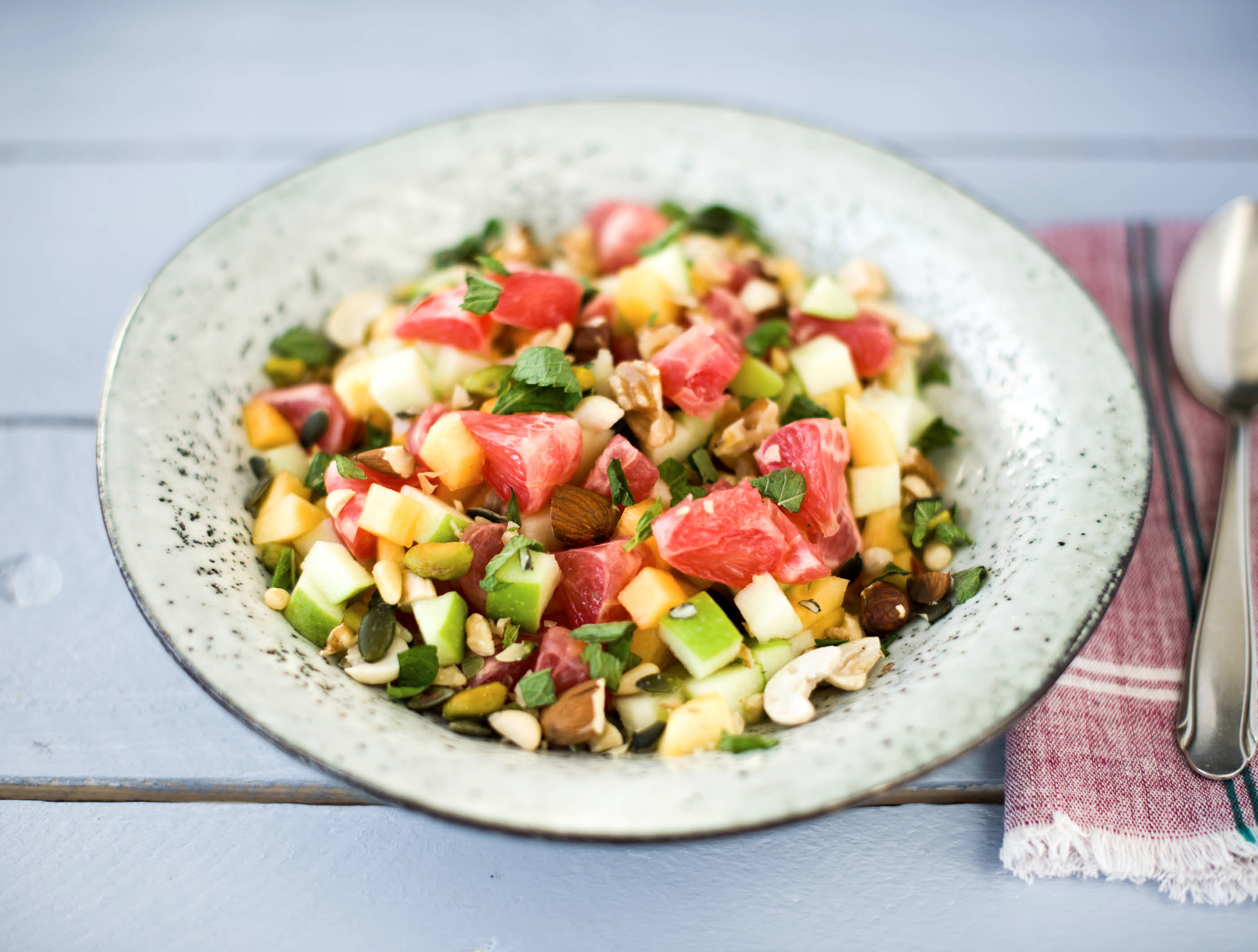 Fruitsalade met een notenmix en verse munt