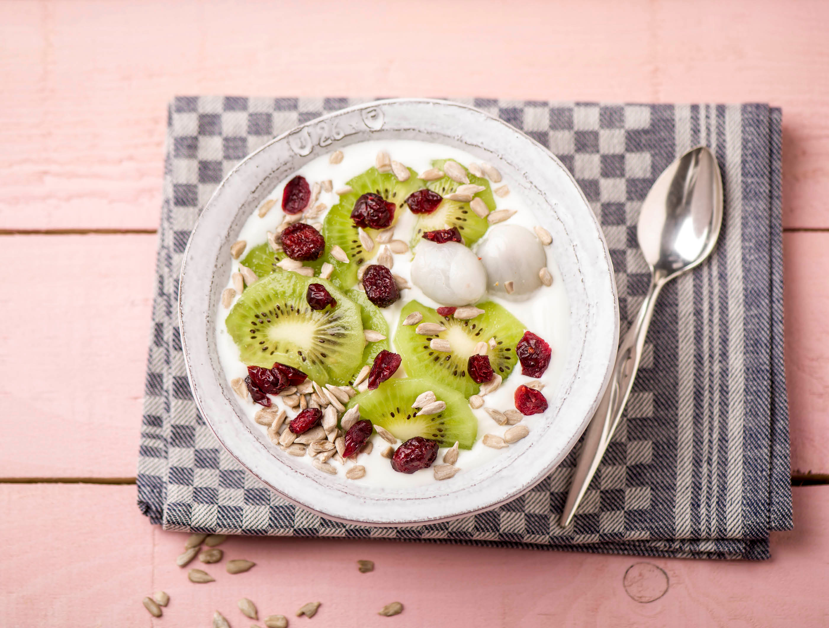 Halfvolle yoghurt met lychees, kiwi en cranberry-pittenmix