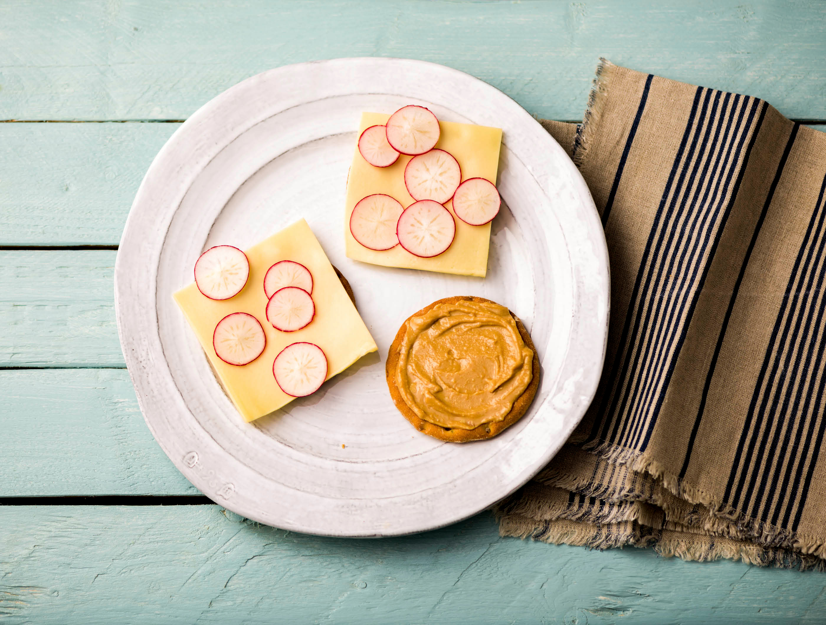 Sesamcrackers met jong belegen kaas, radijs en pindakaas