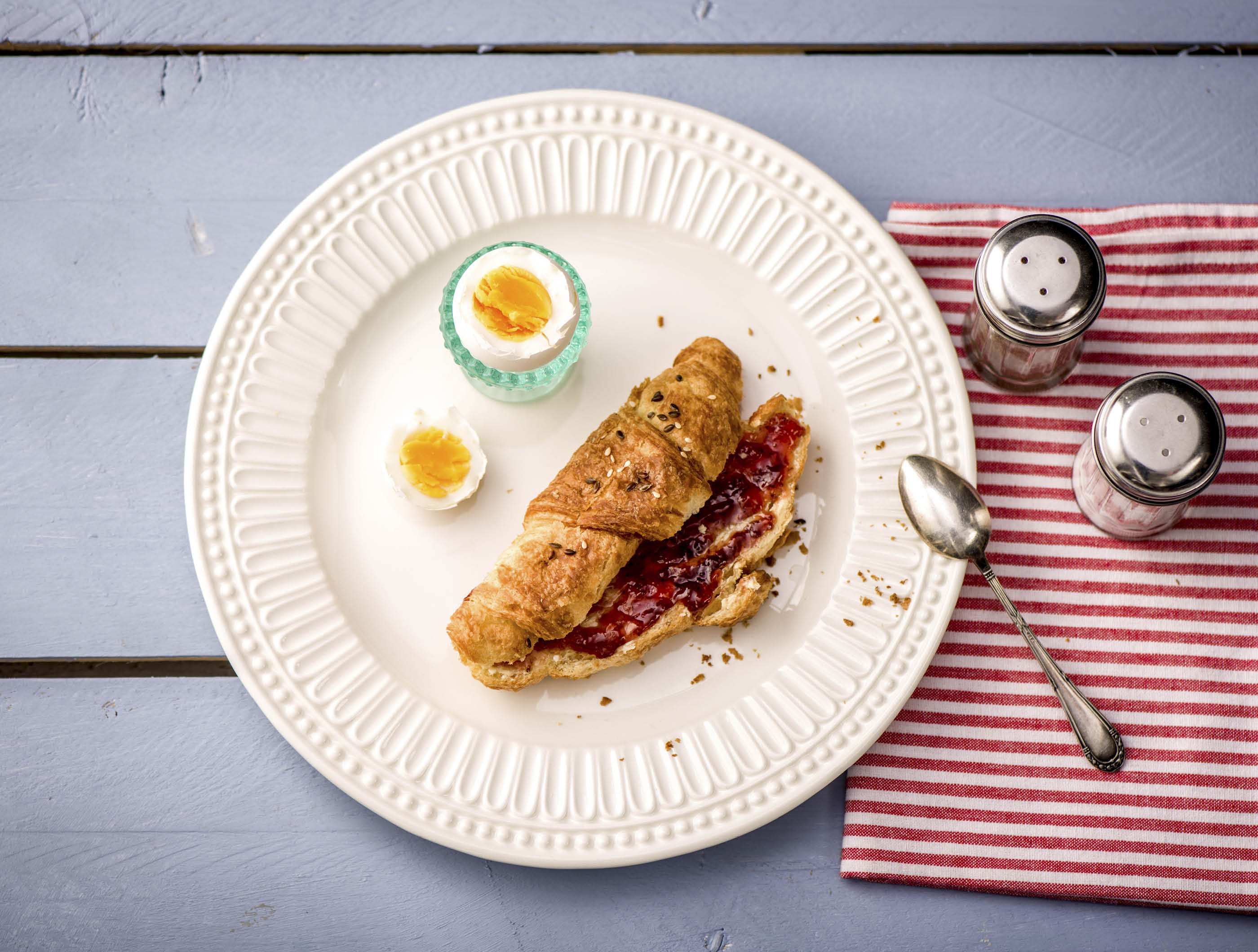 Frans ontbijt met croissants, aardbeienjam en een gekookt eitje