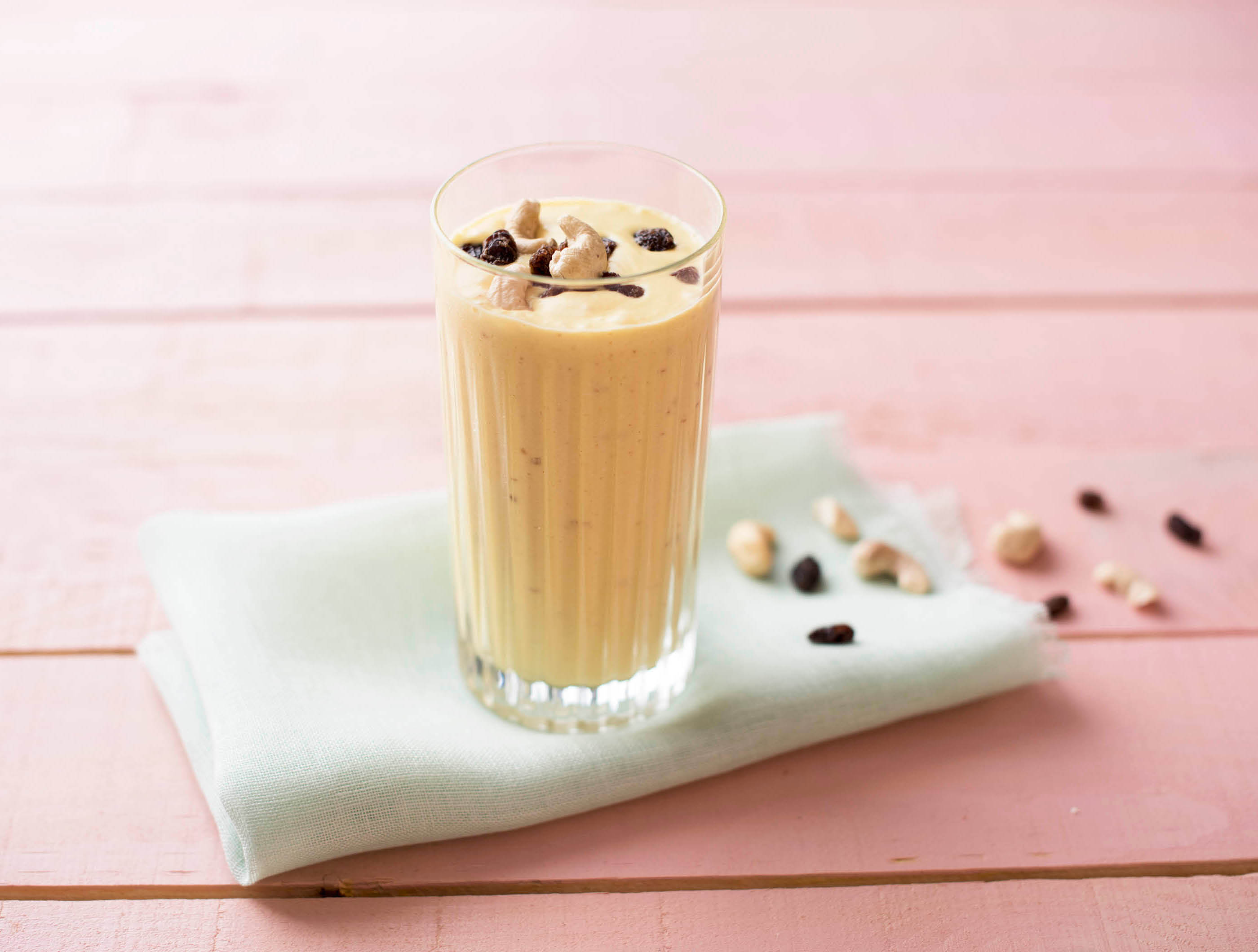 Mango-kokossmoothie met cashewnoten-rozijnenmix
