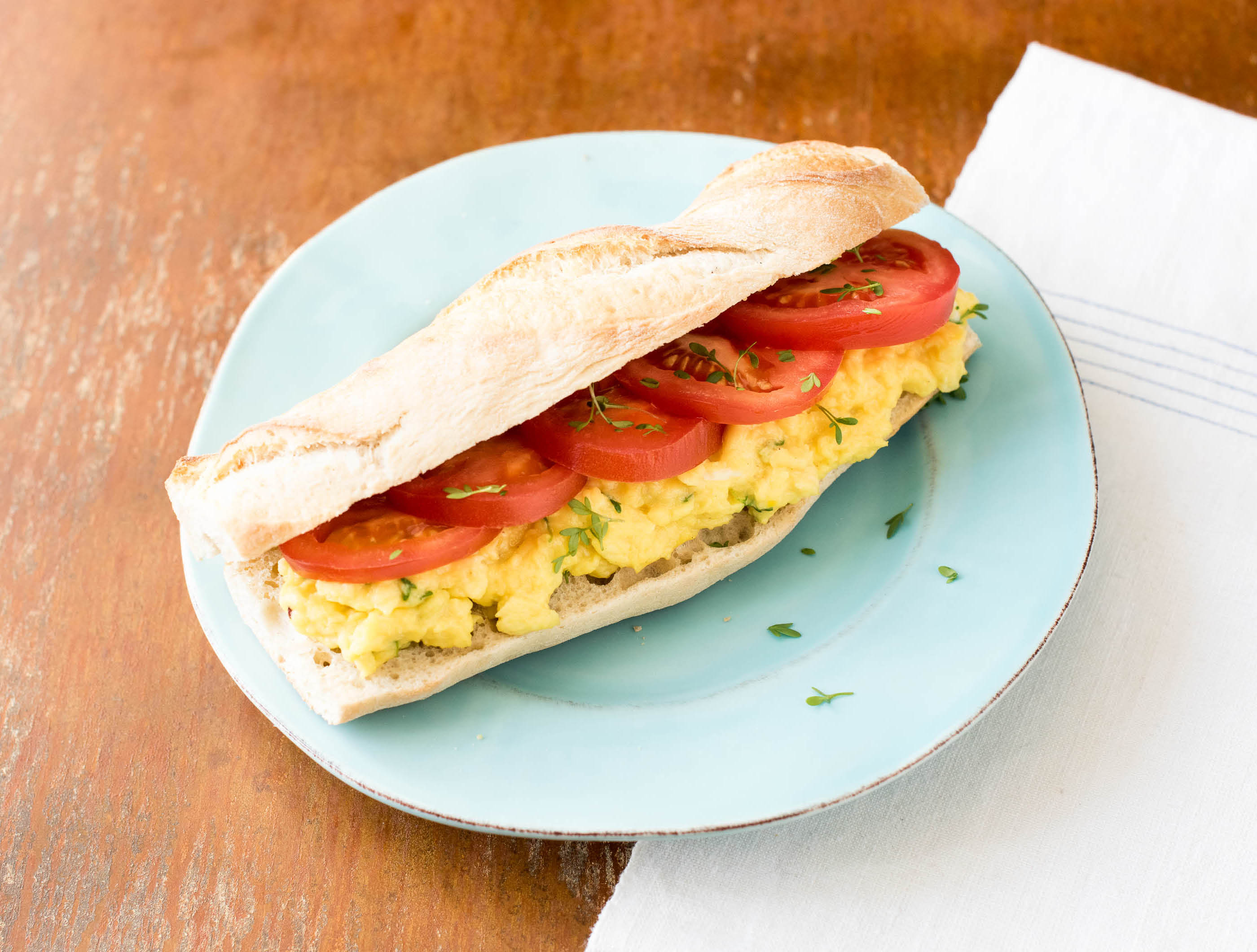 Speltbaguette met roerei, tomaat en tuinkers