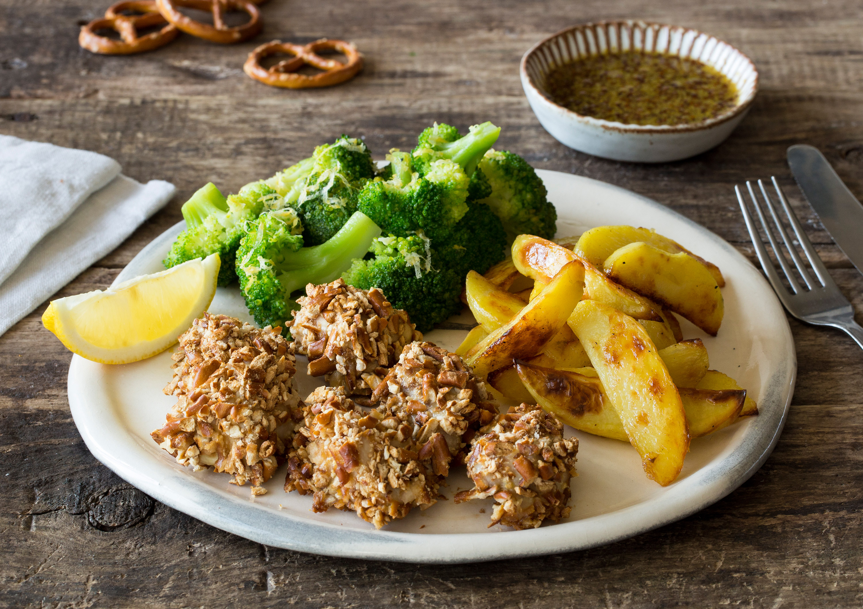 Ofen-Poulet in Brezelpanade mit knusprigen Kartoffel-Wedges,