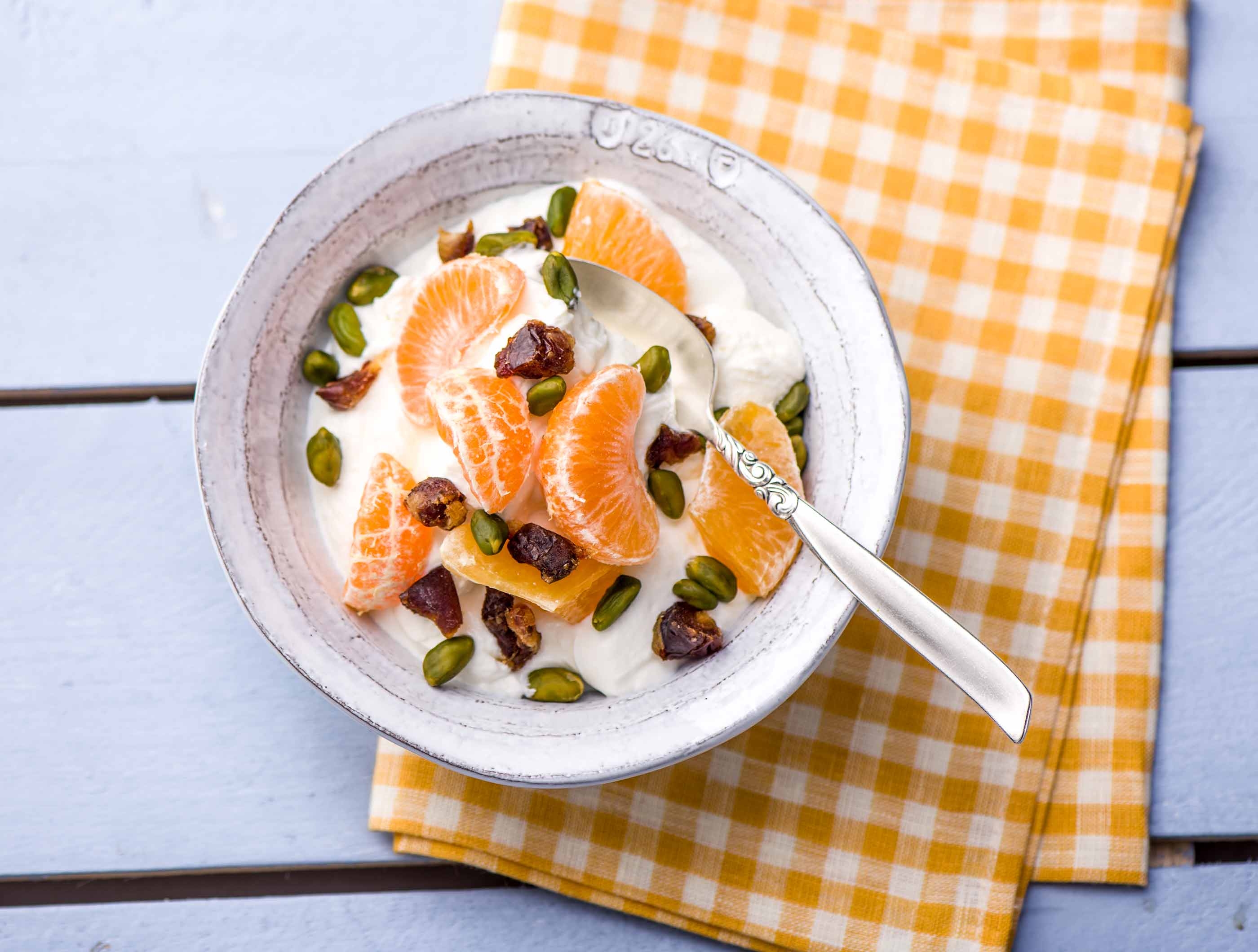 Volle kwark met oranje fruit, noten en dadels