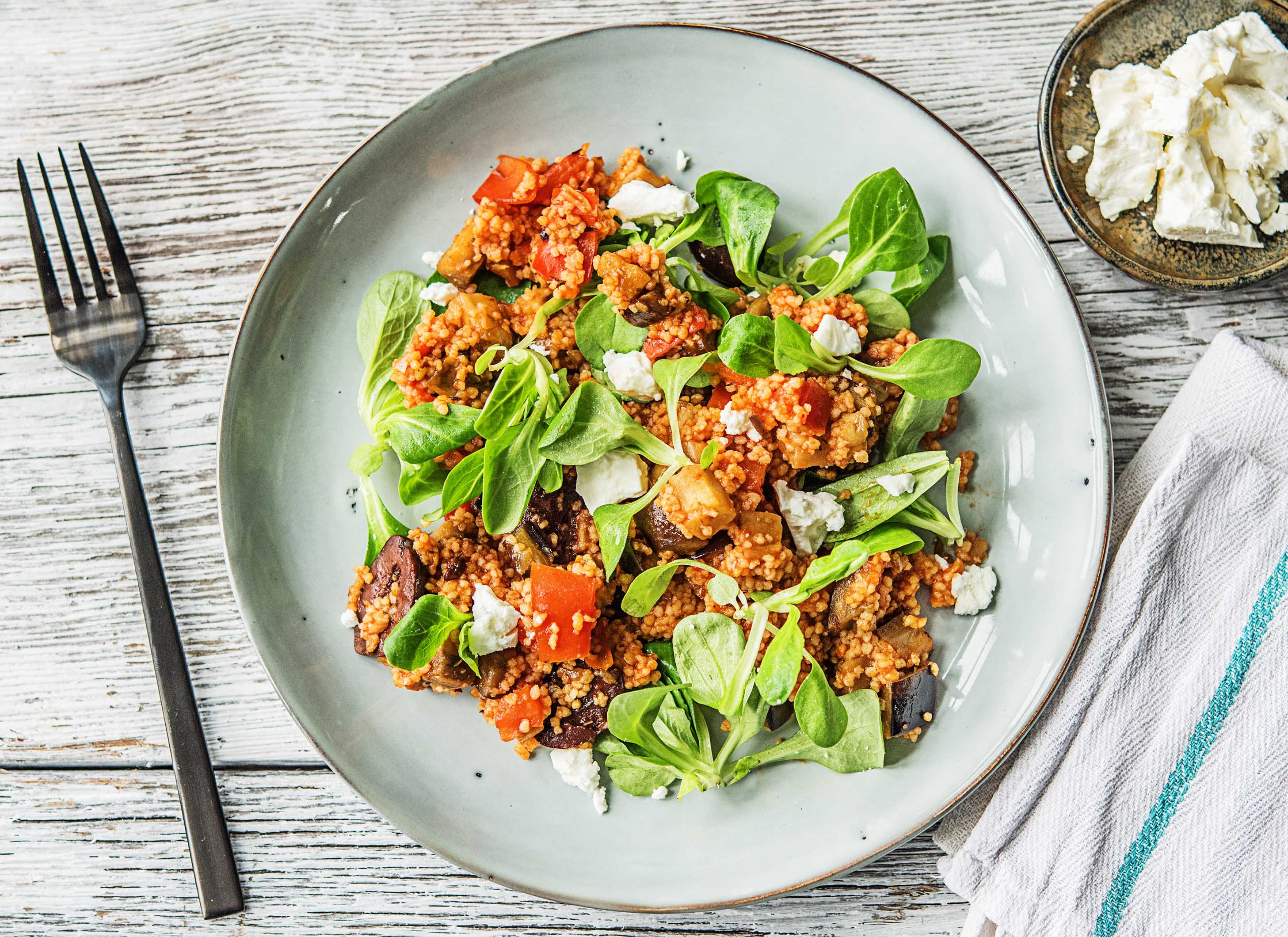 Pikante harissacouscous met feta, aubergine, tomaat en olijven