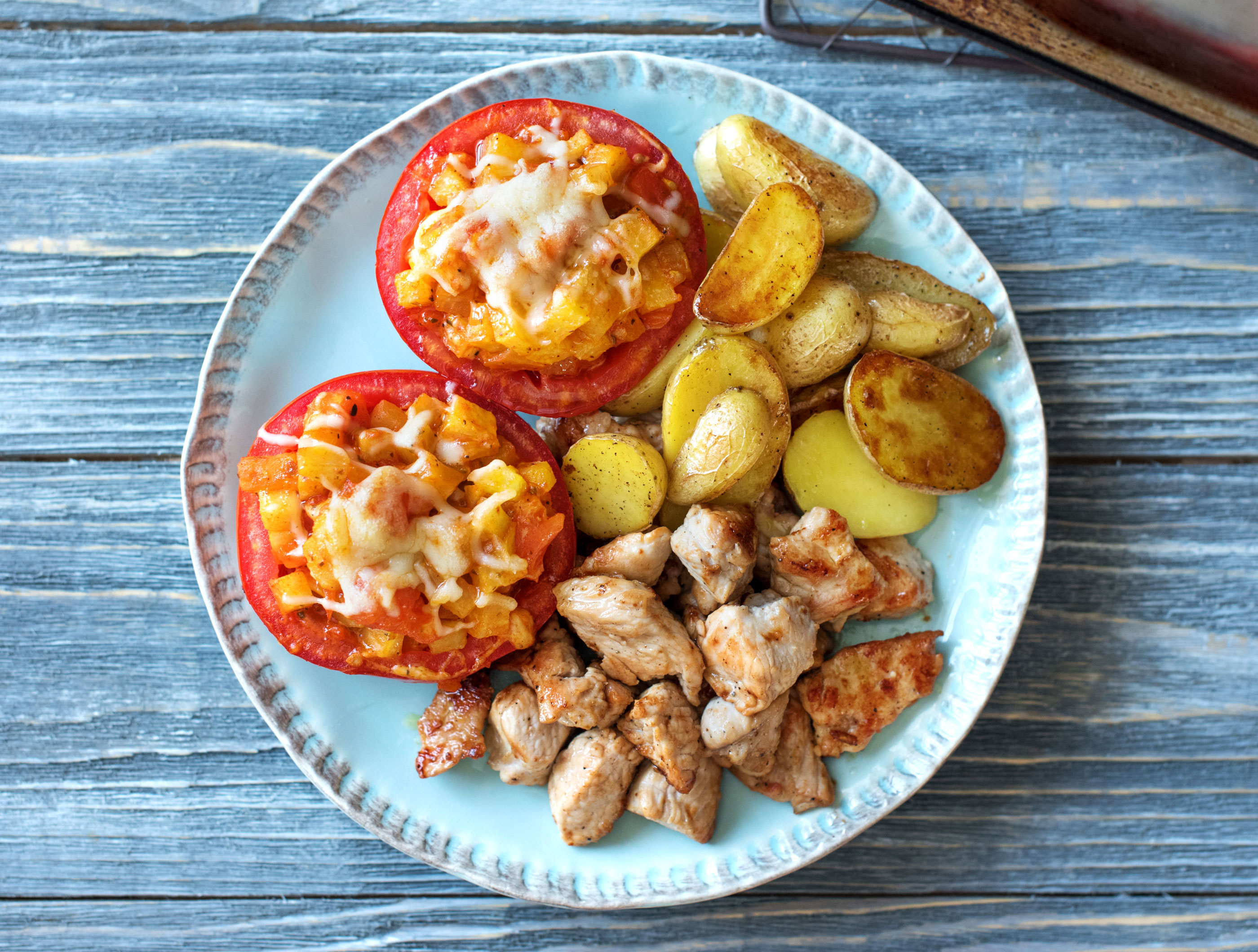 Filets de poulet, tomates cœur de bœuf farcies et grenailles à l'origan