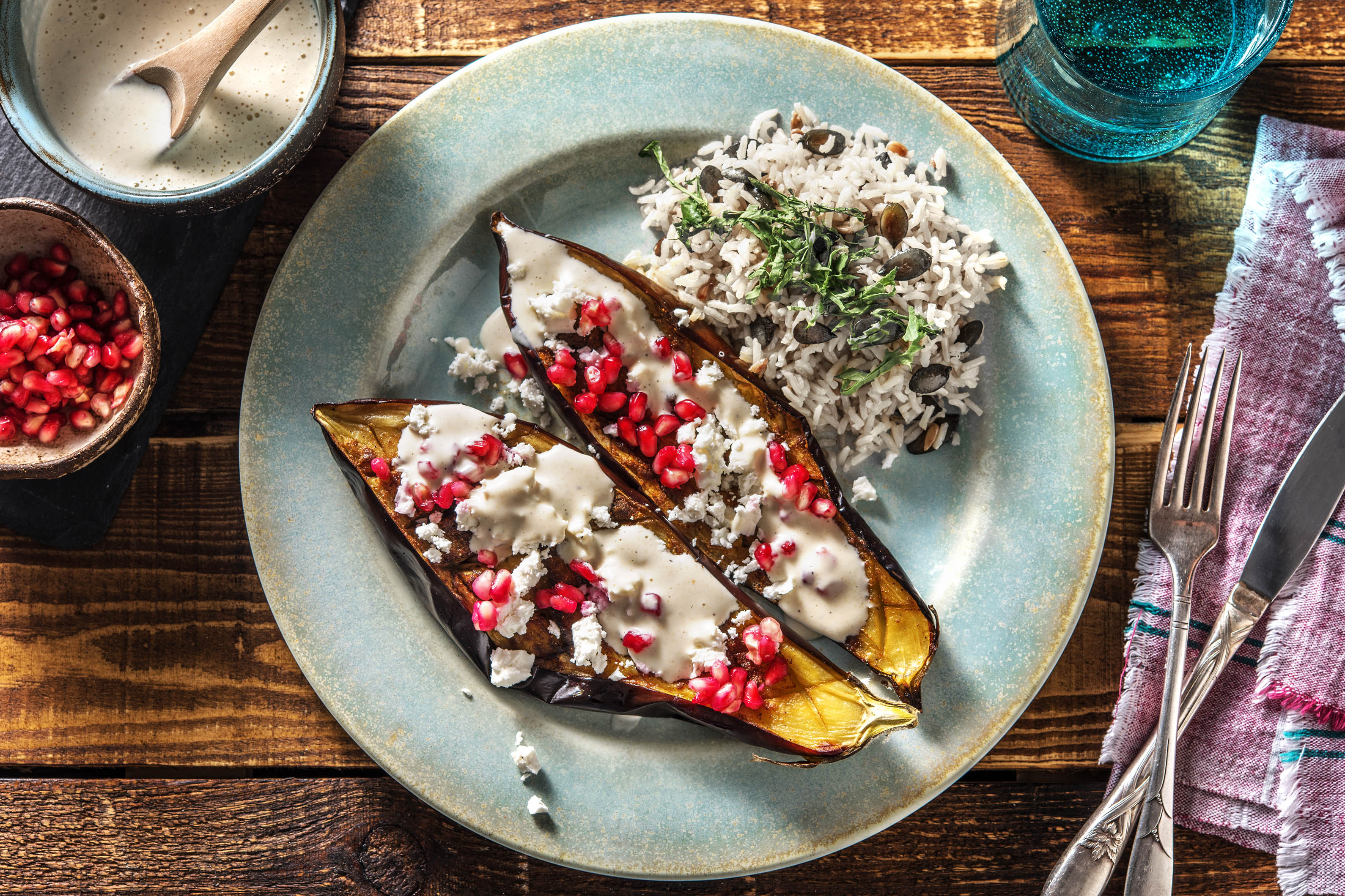 Aubergine uit de oven met feta, granaatappelpitjes en yoghurt-tahinsaus