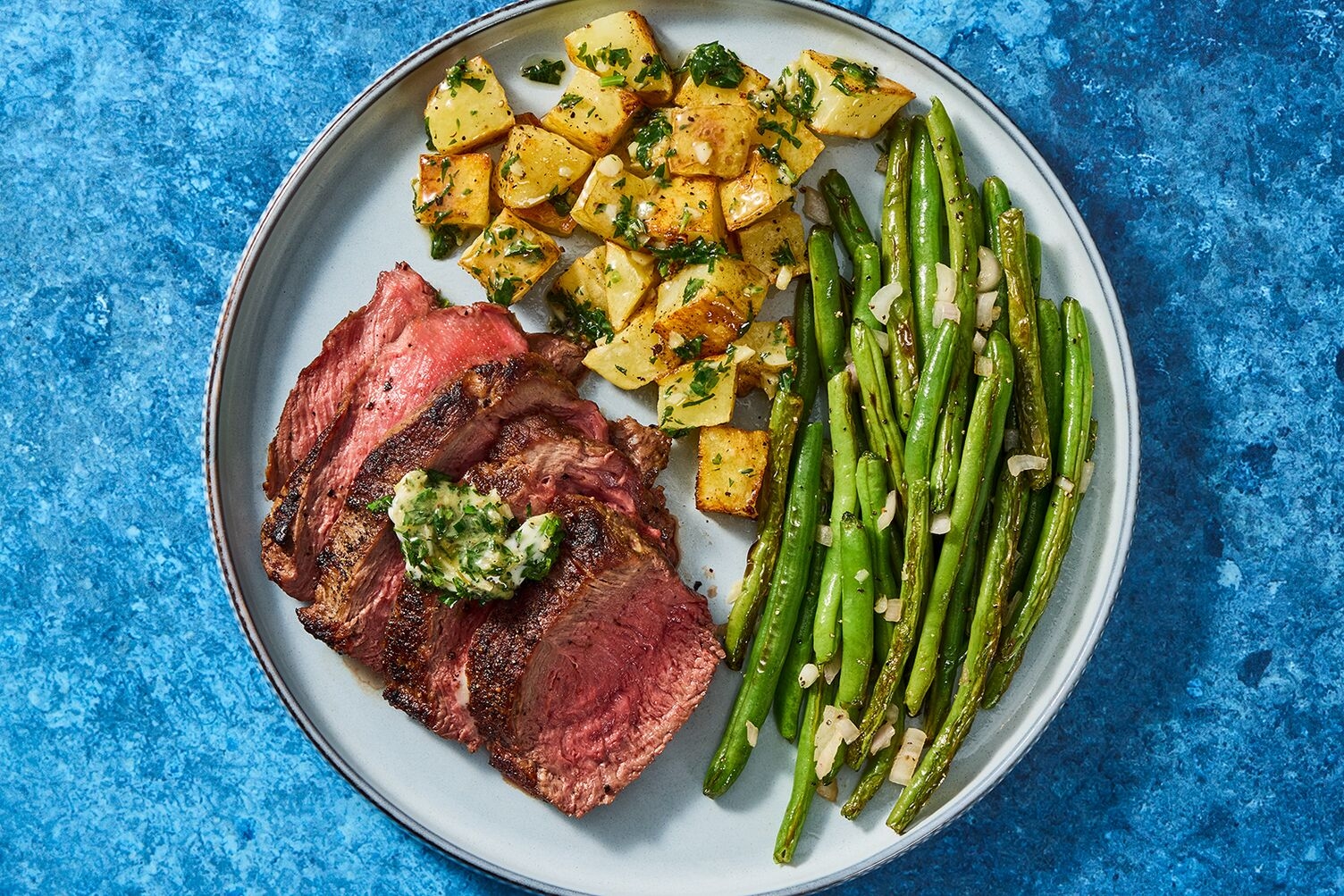 Steaks de double contre-filet poêlés avec beurre à l’ail et aux fines herbes
