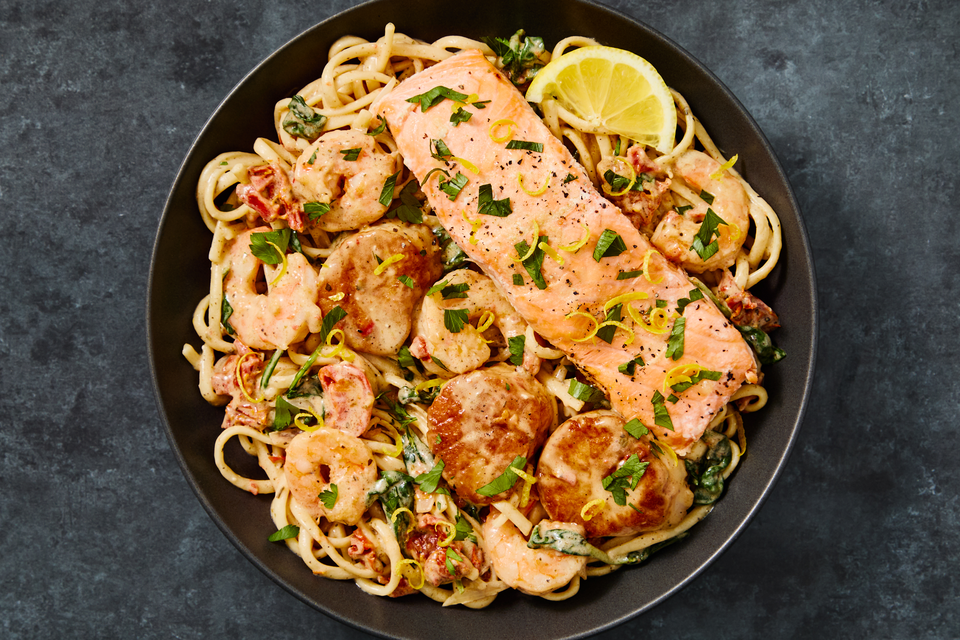 Salmon “en Papillote” over Seafood Linguine