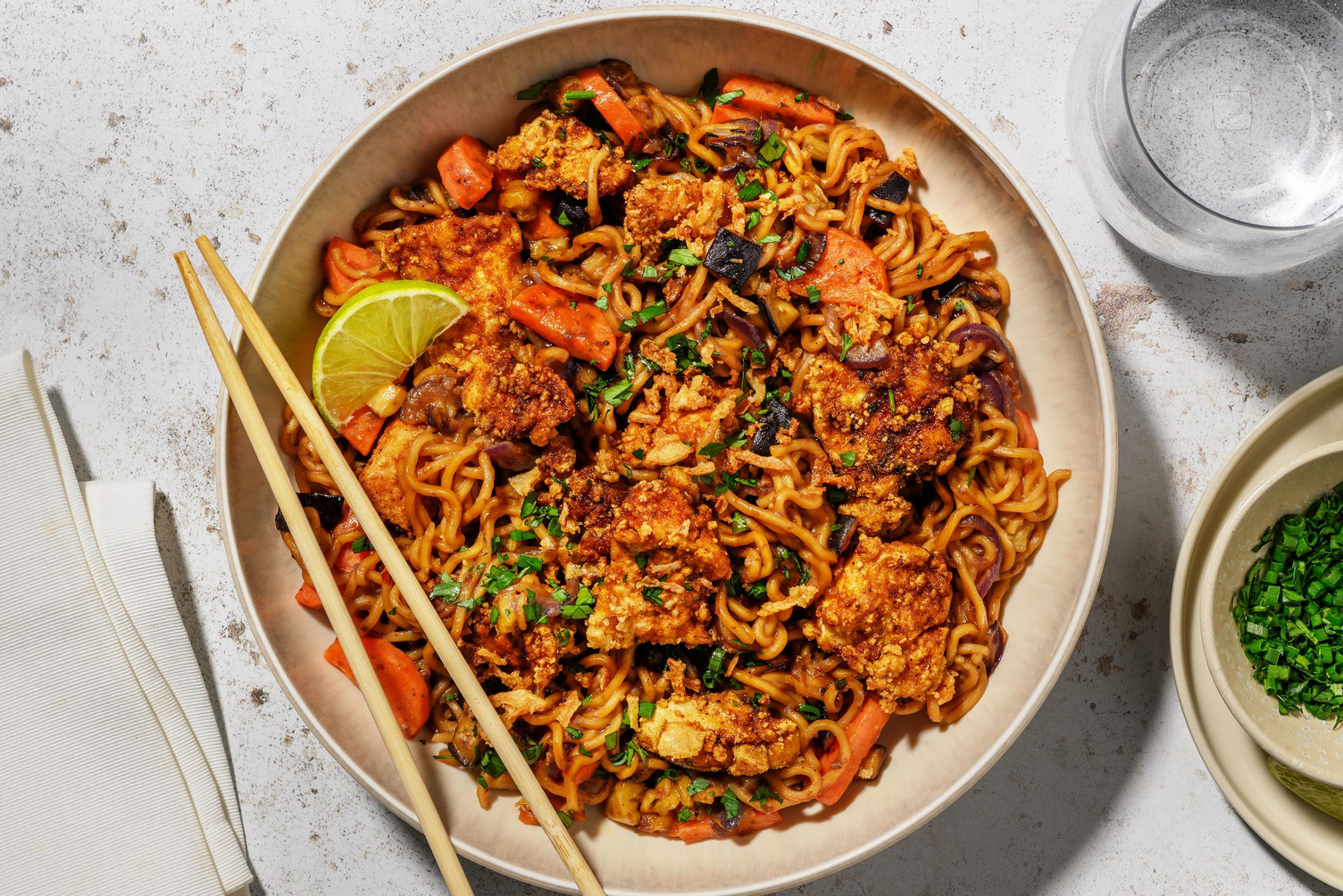 Noedels in zwartebonensaus met tofu, limoen en verse kruiden