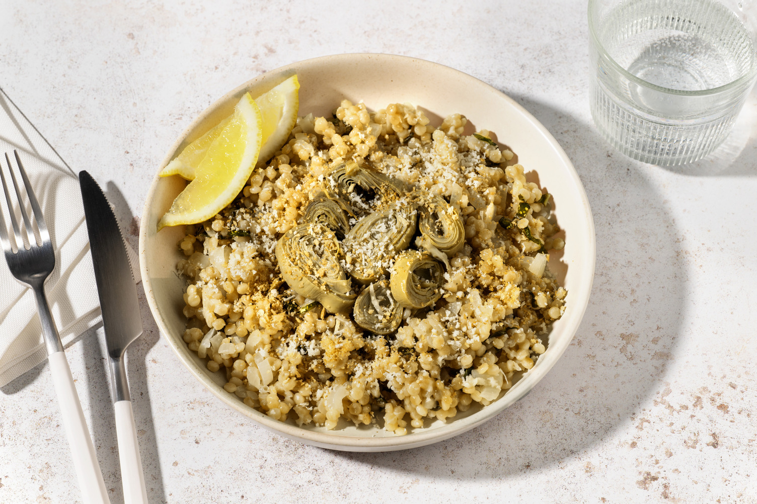 Bowl di couscous perlato, salsiccia e carciofi