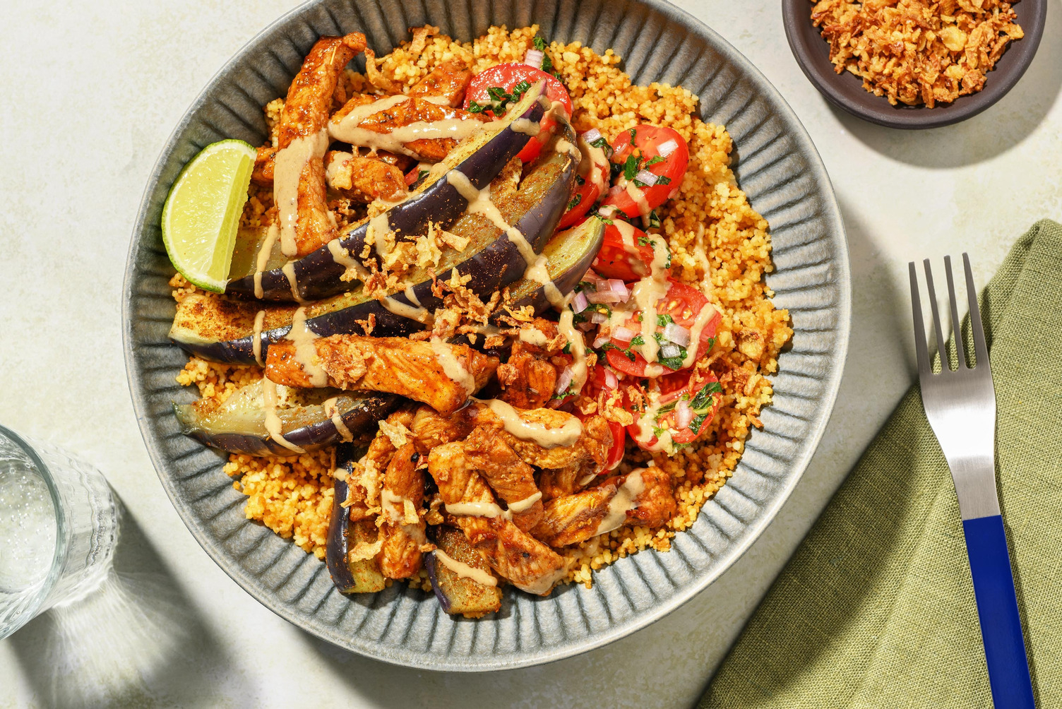 Couscousbowl met varkensreepjes, aubergine en tahinsaus