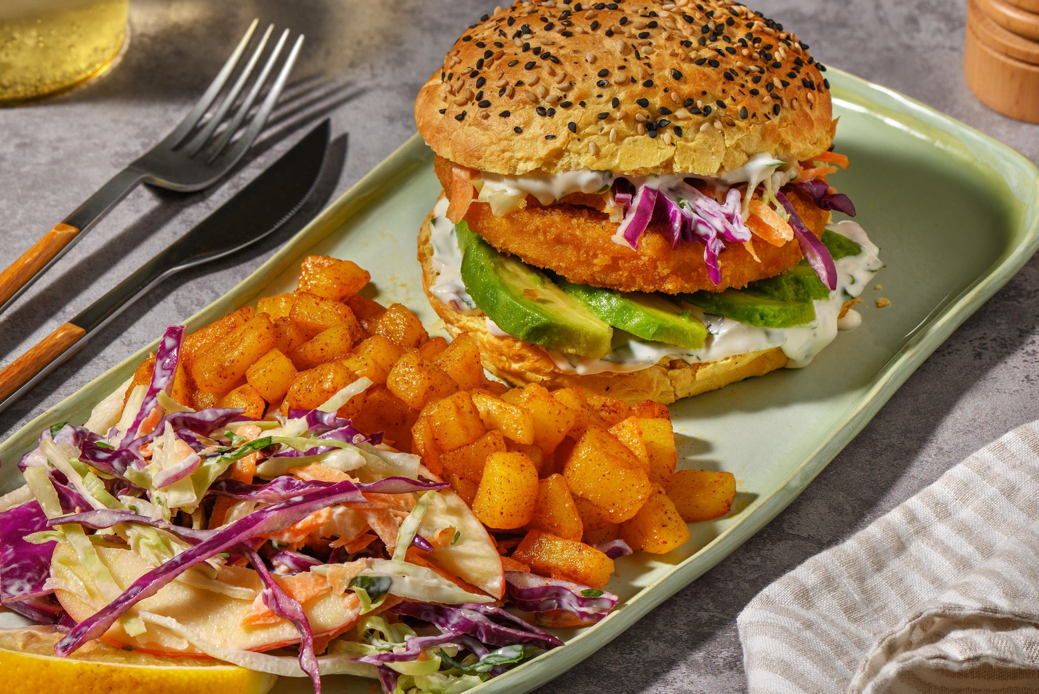 Plantaardige visburger op een wortelbroodje met avocado