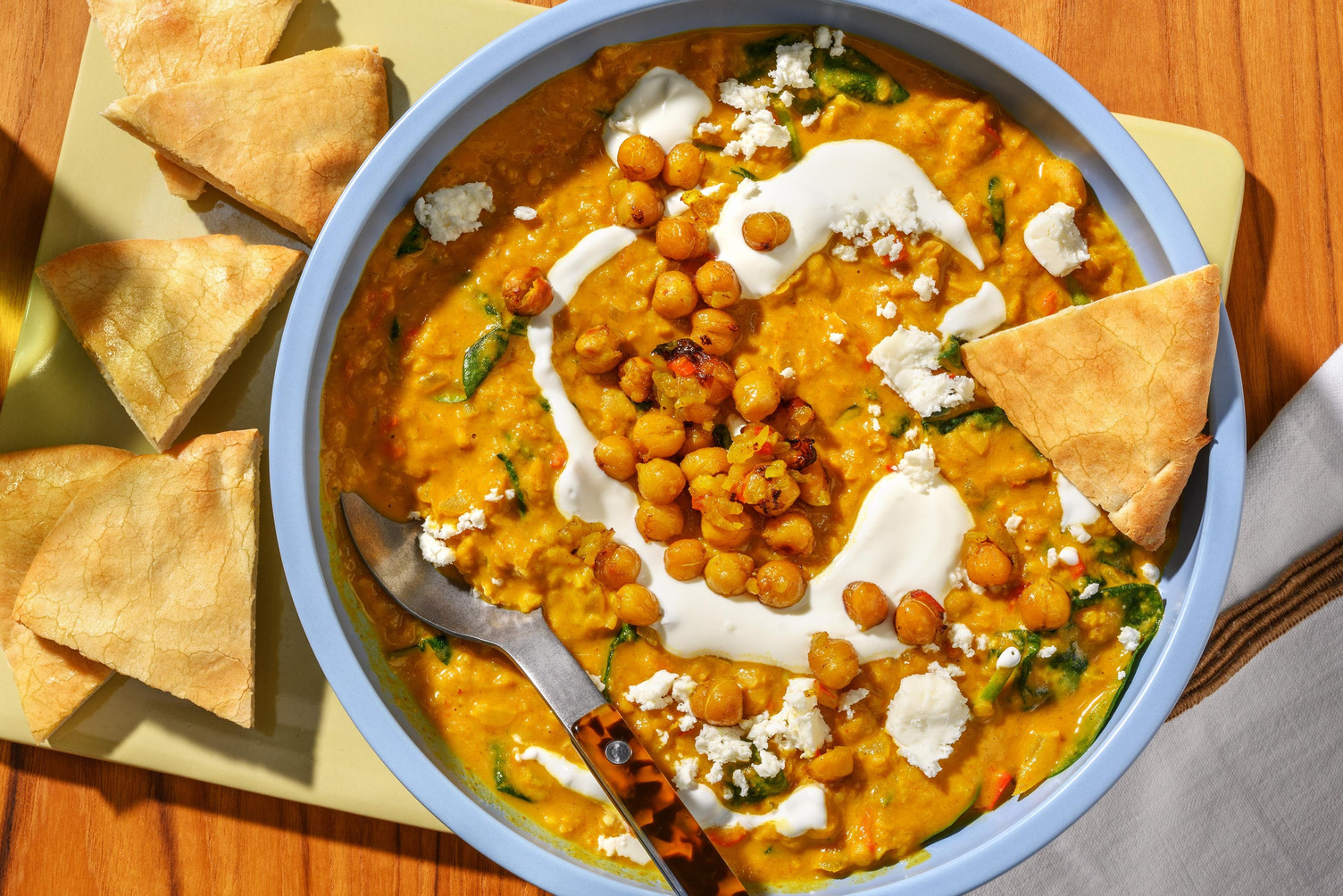 Romige curry met knapperige kikkererwtentopping en pita