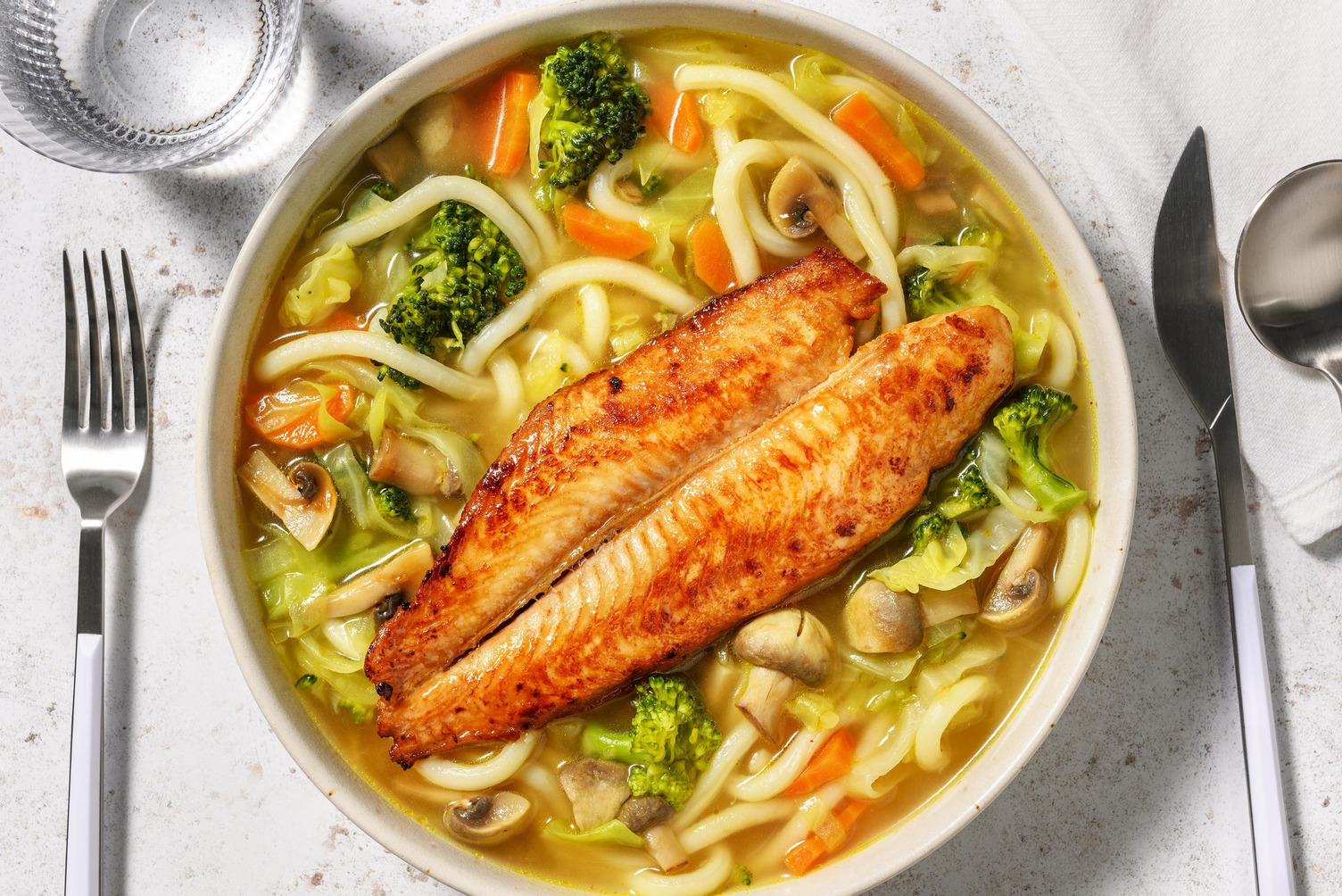 Kruidige udonnoedelsoep met gebakken pangasiusfilet