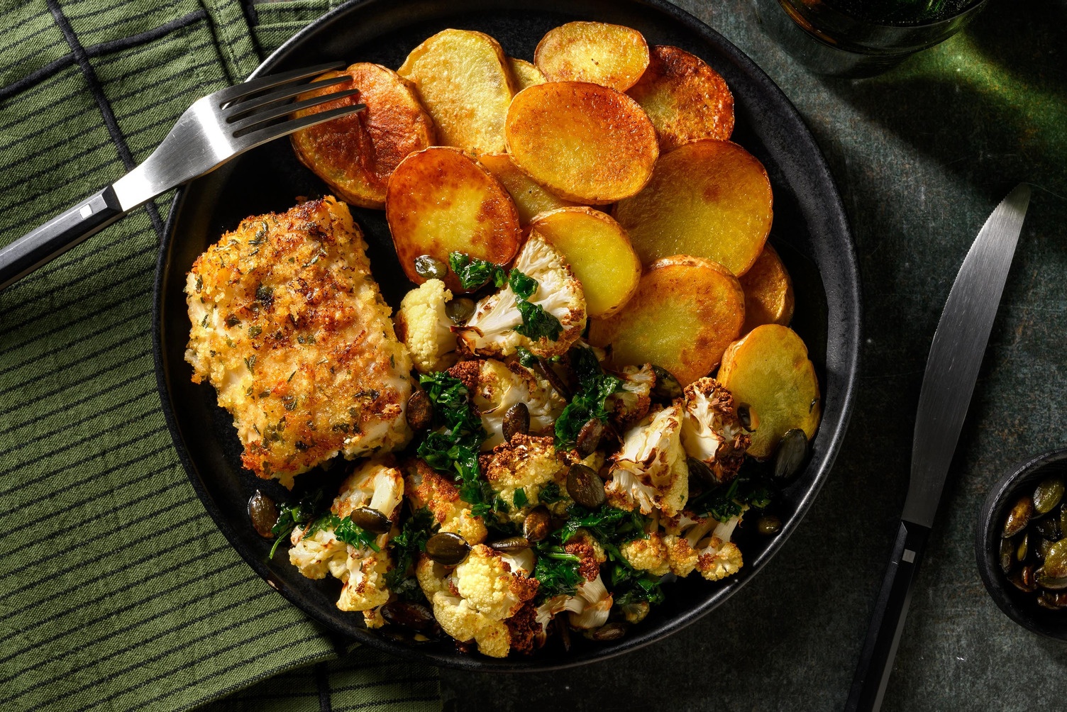 Gepaneerde kabeljauw met knoflook-peterselieolie en pompoenpitten