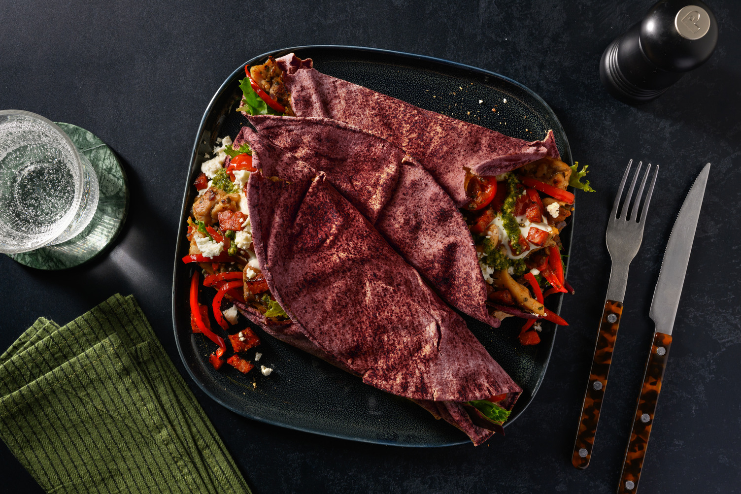 Platbrood met kippendijreepjes, chorizo, feta en zhoug