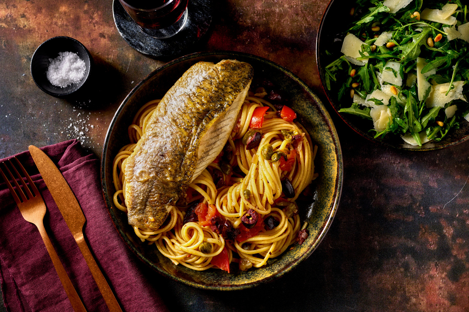 Italiensk vit fisk på oliv- och tomatlinguine