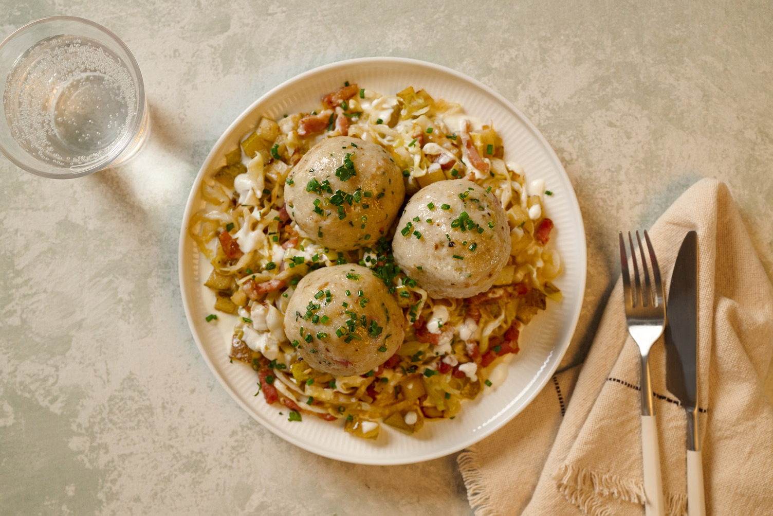 Knödel mit doppelt Bacon auf warmem Krautsalat