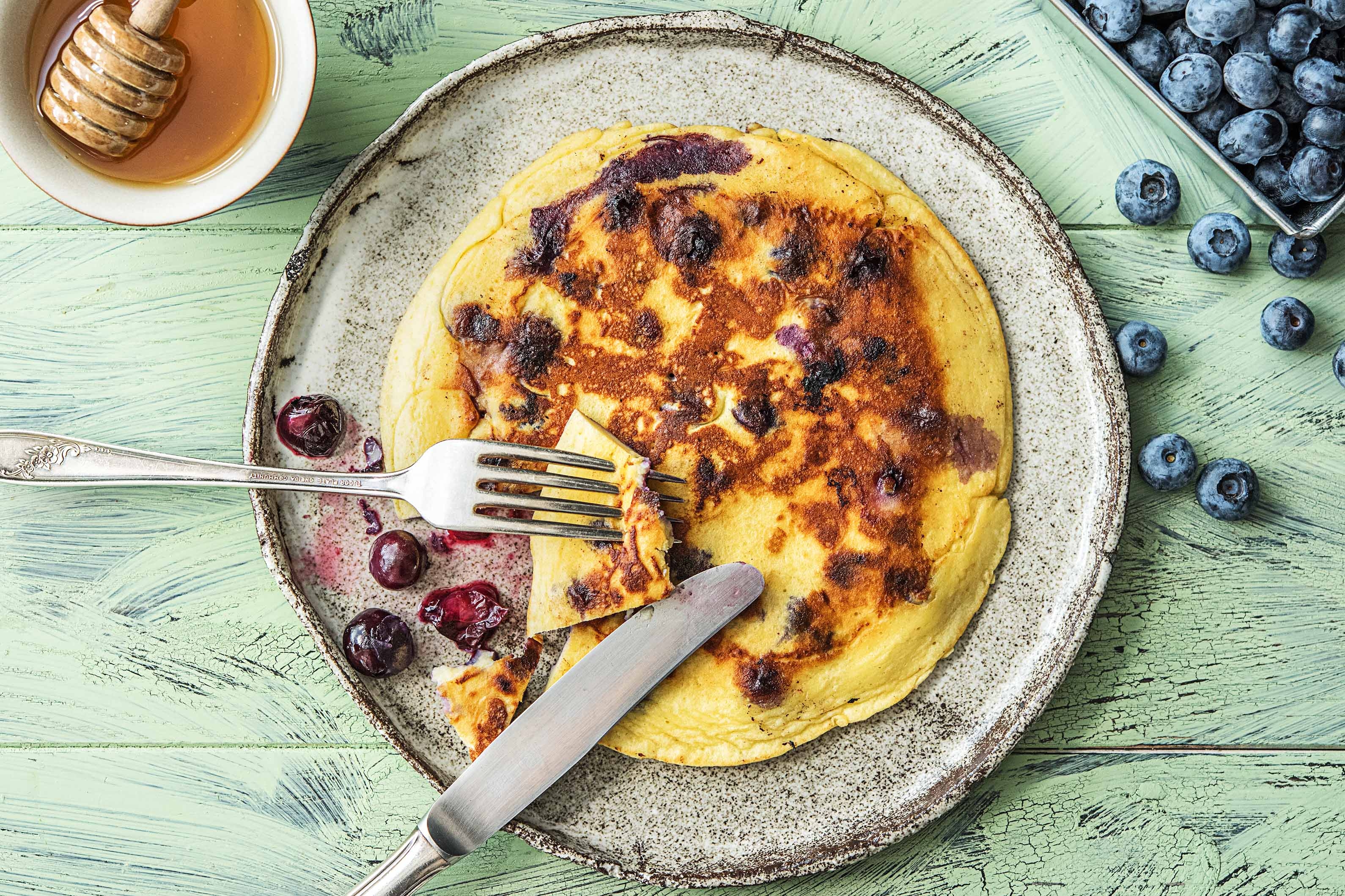 Amandelpannenkoeken met blauwe bessen en honing