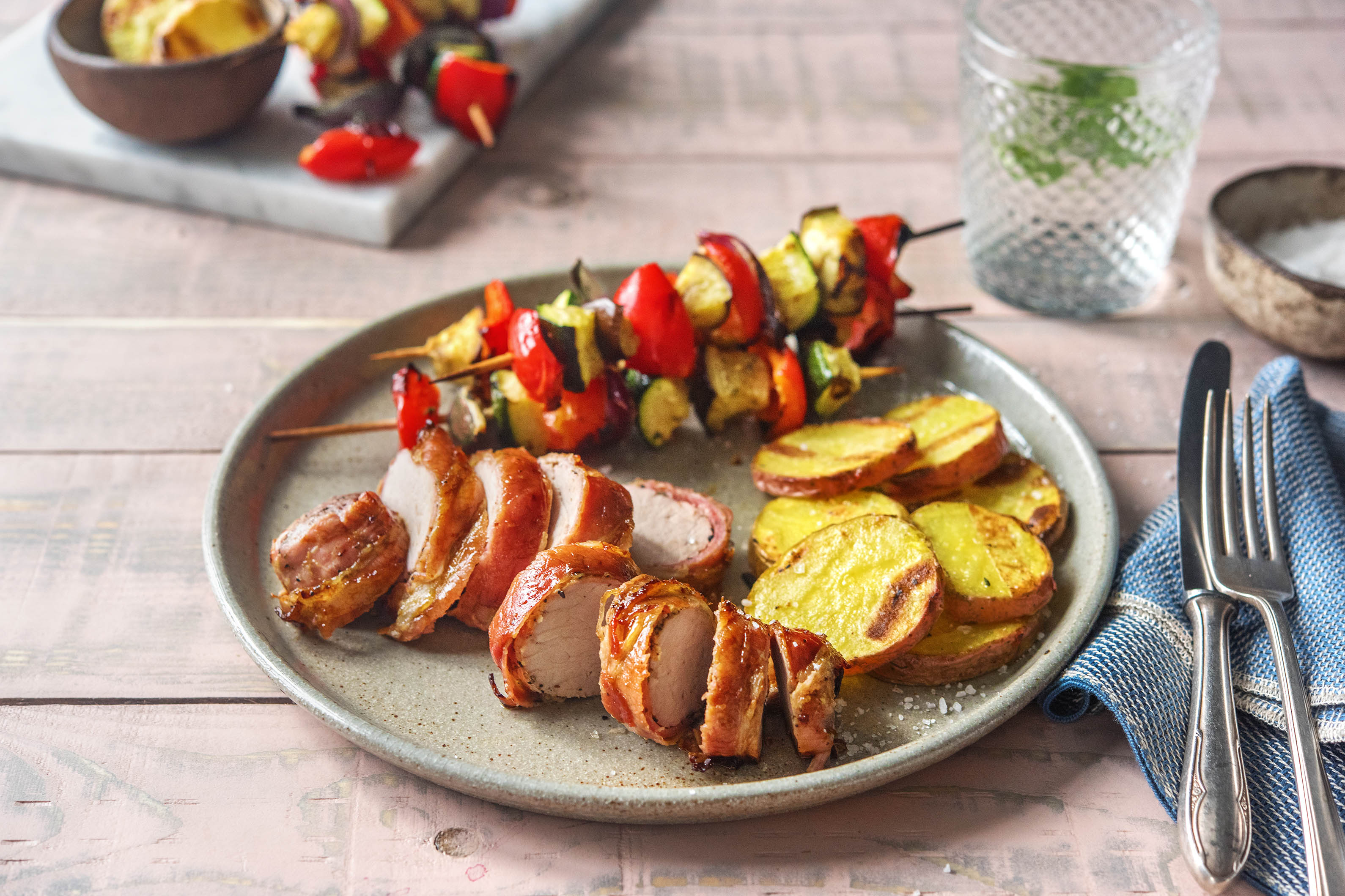 Klassisches Schweinefilet in gegrilltem Bacon-Mantel mit Gemüsespießen