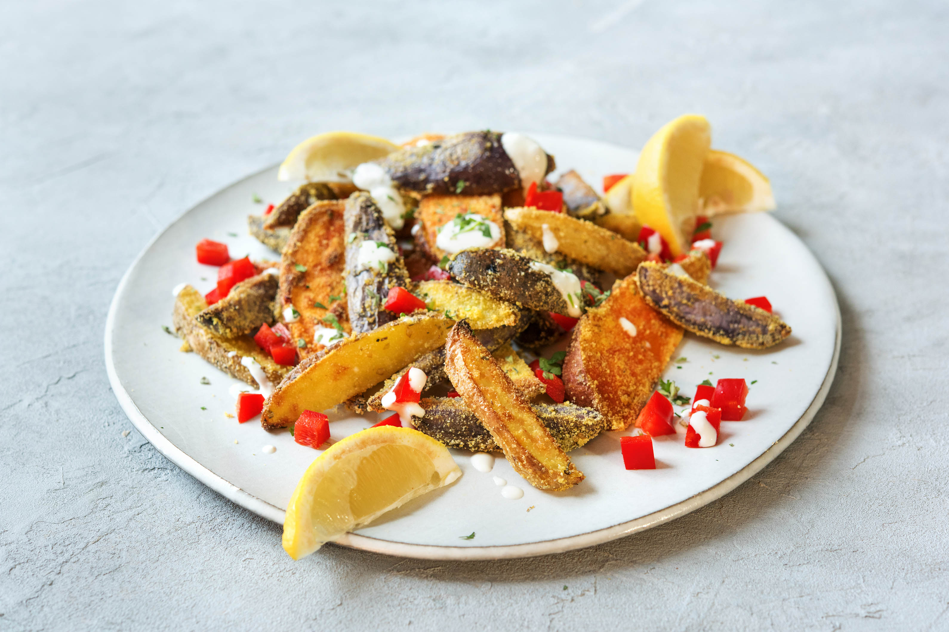 Bunte Kartoffelspalten mit Feta Crème und Kräutern