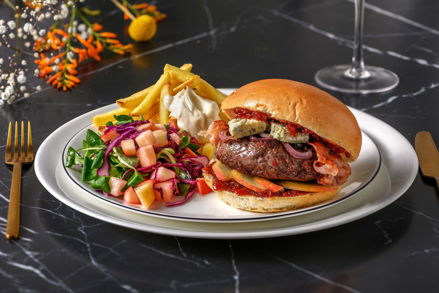 Burger de sanglier accompagné de frites au four et d'une salade de chou et pomme