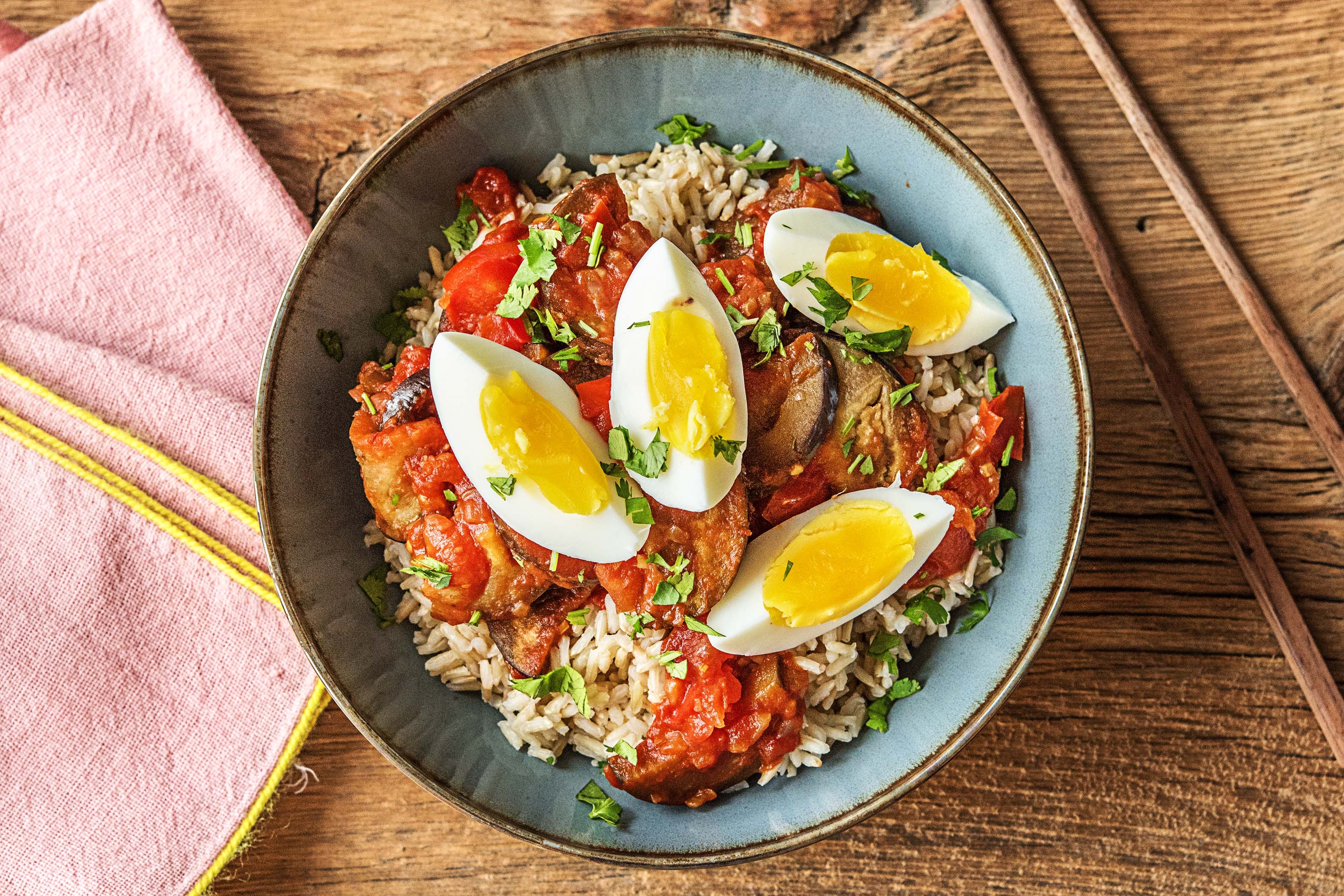 Indonesische smoor terong met rijst, ei, zoete tomaat en zachte aubergine