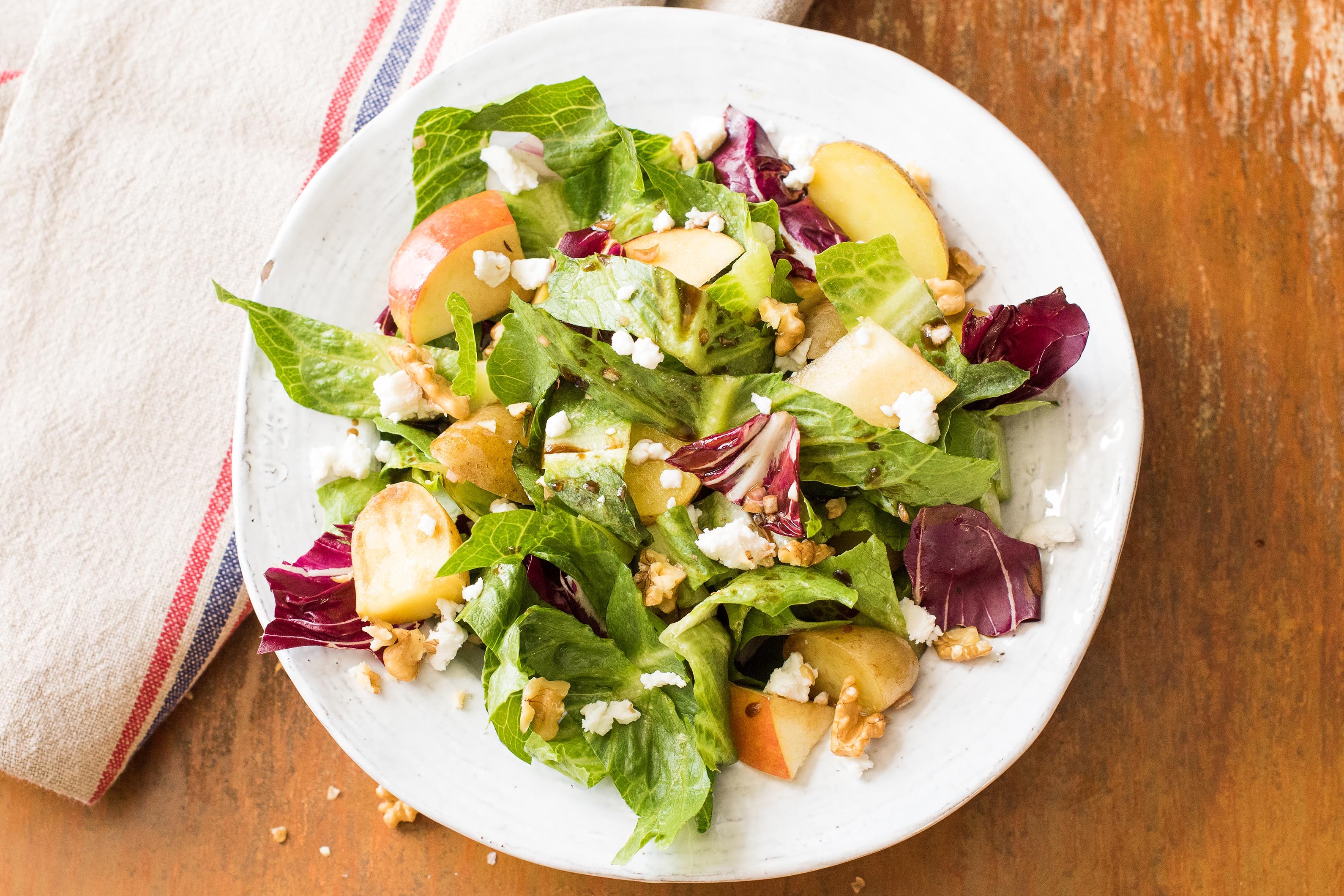 Krieltjessalade met appel en geitenkaas, walnoten, honing en gemengde sla