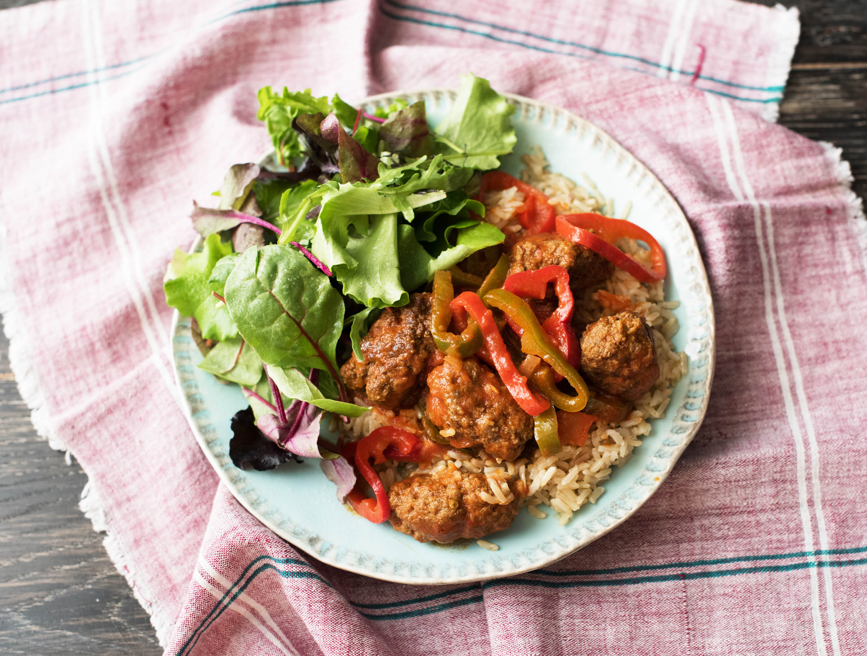 Kruidige köfte in zoetpittige saus met rijst en salade