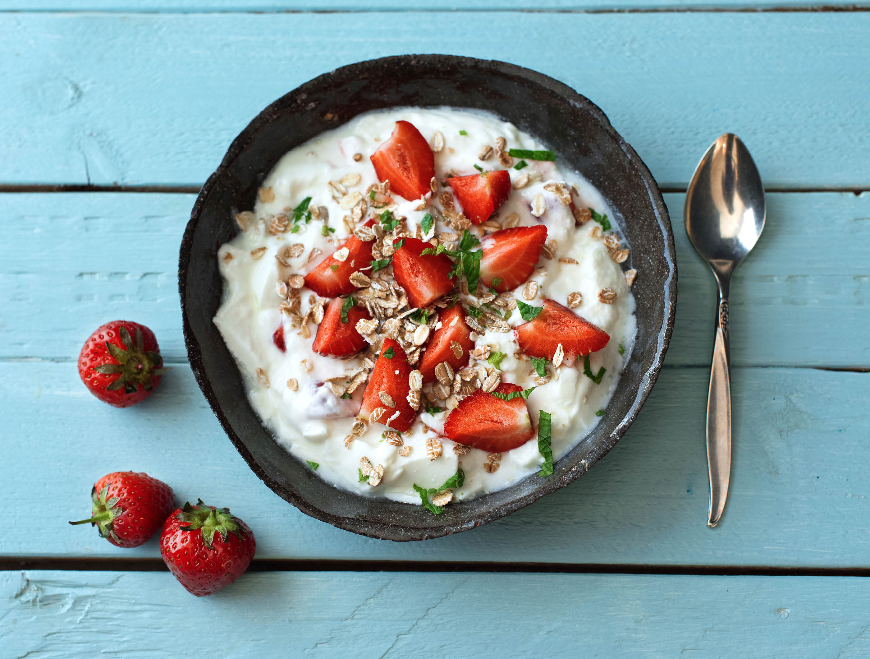 Magere yoghurt met aardbeien, verse munt en muesli