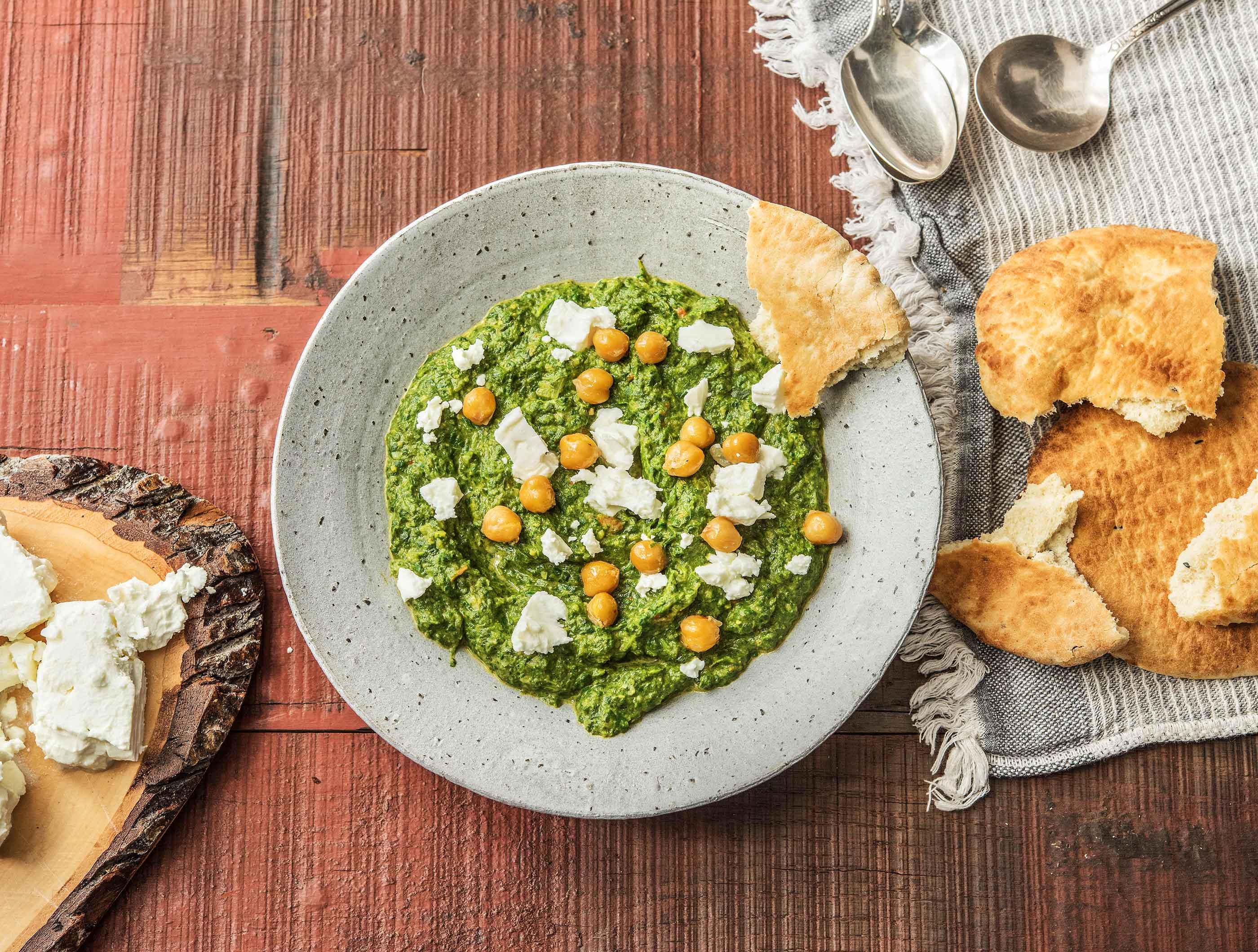 Palak met feta, kikkererwten, naanbrood, crème fraîche en kurkuma